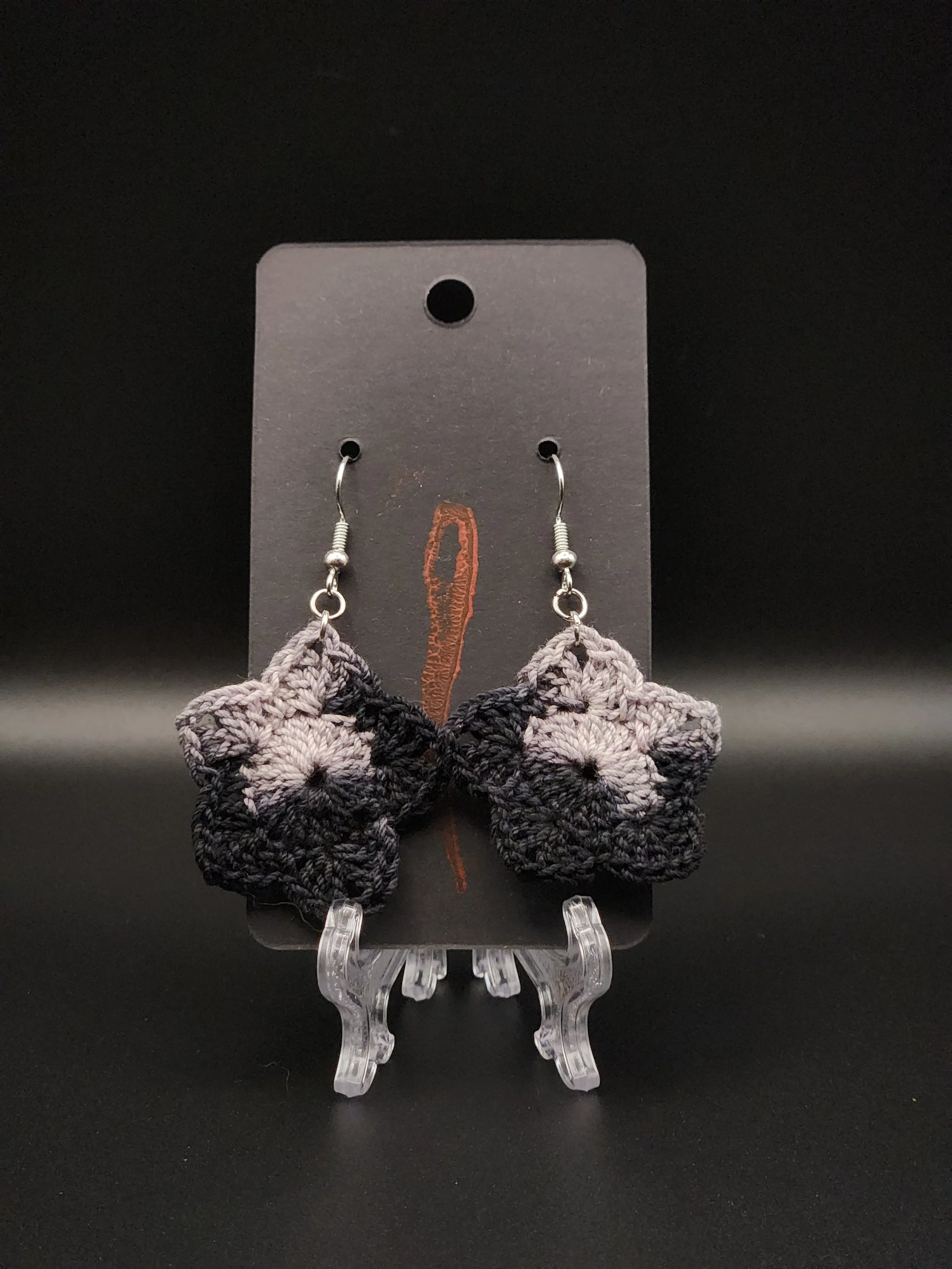 Black and gray crocheted bear-shaped earrings displayed on a black background with a black earring card.