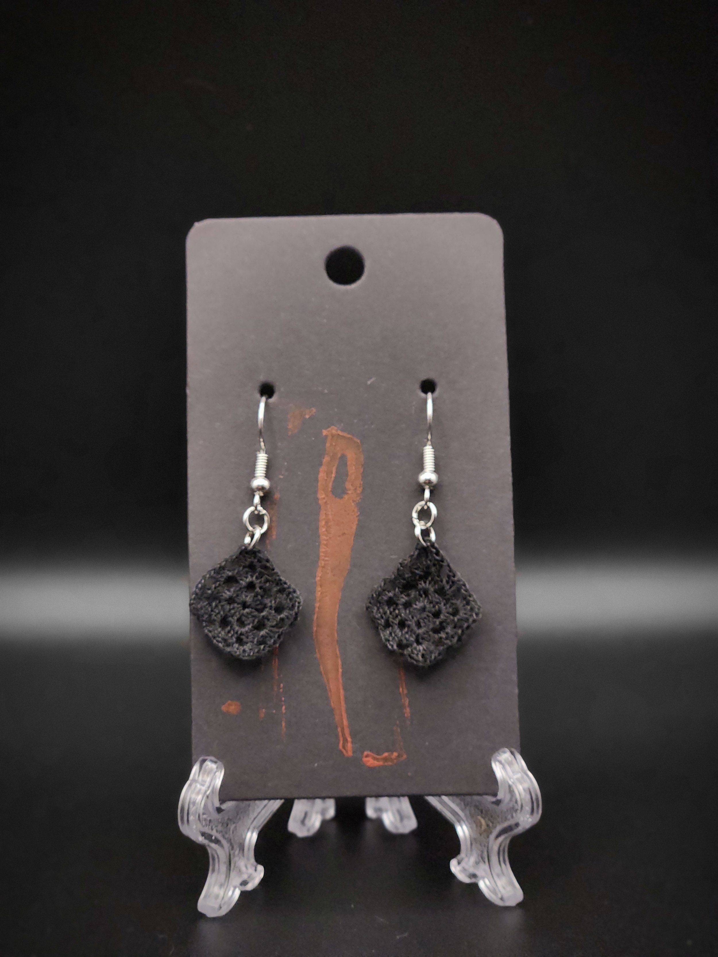 Black lace earrings with silver hooks on a black display card