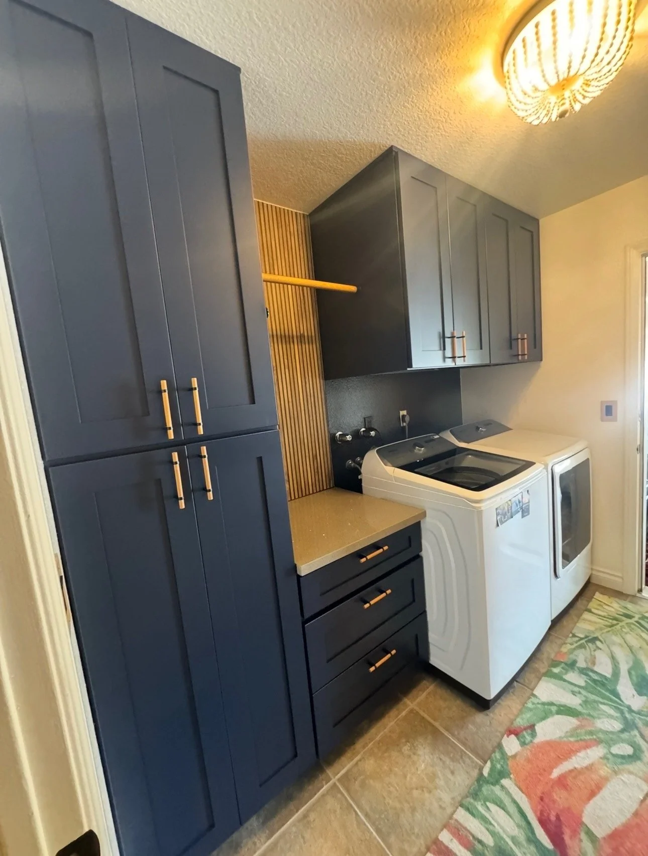 (After photo). Laundry room remodel for project May 30th  we added 4 tall cabinets, 4 medium cabinets, 3 drawers with a pullout ironing board, tile walls, quartz top, clothes rack. 