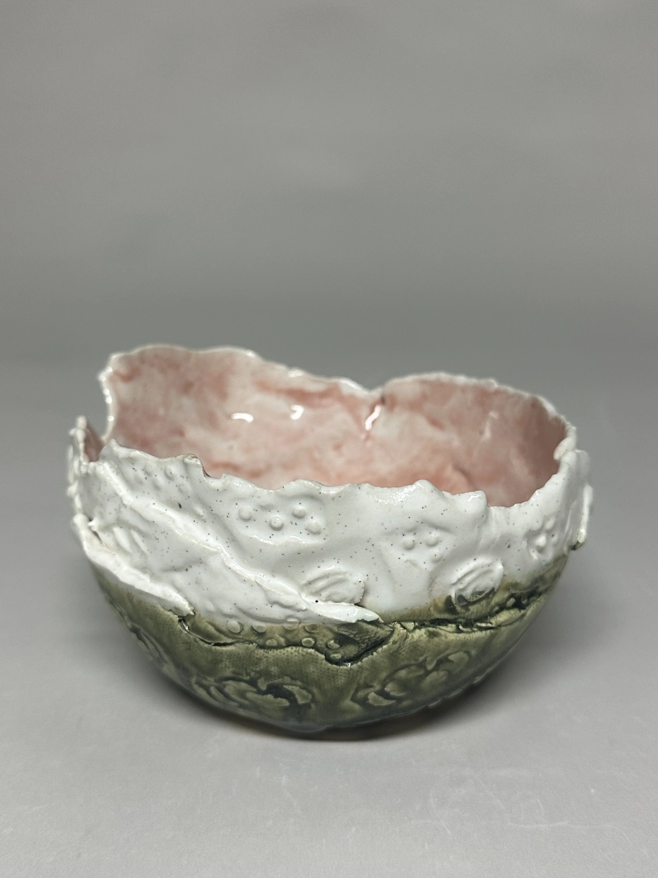 A small, delicate layered bowl glazed with Santorini Ash, soft oatmeal, and pink glazes, finished with handmade stamps for added texture. SOLD!