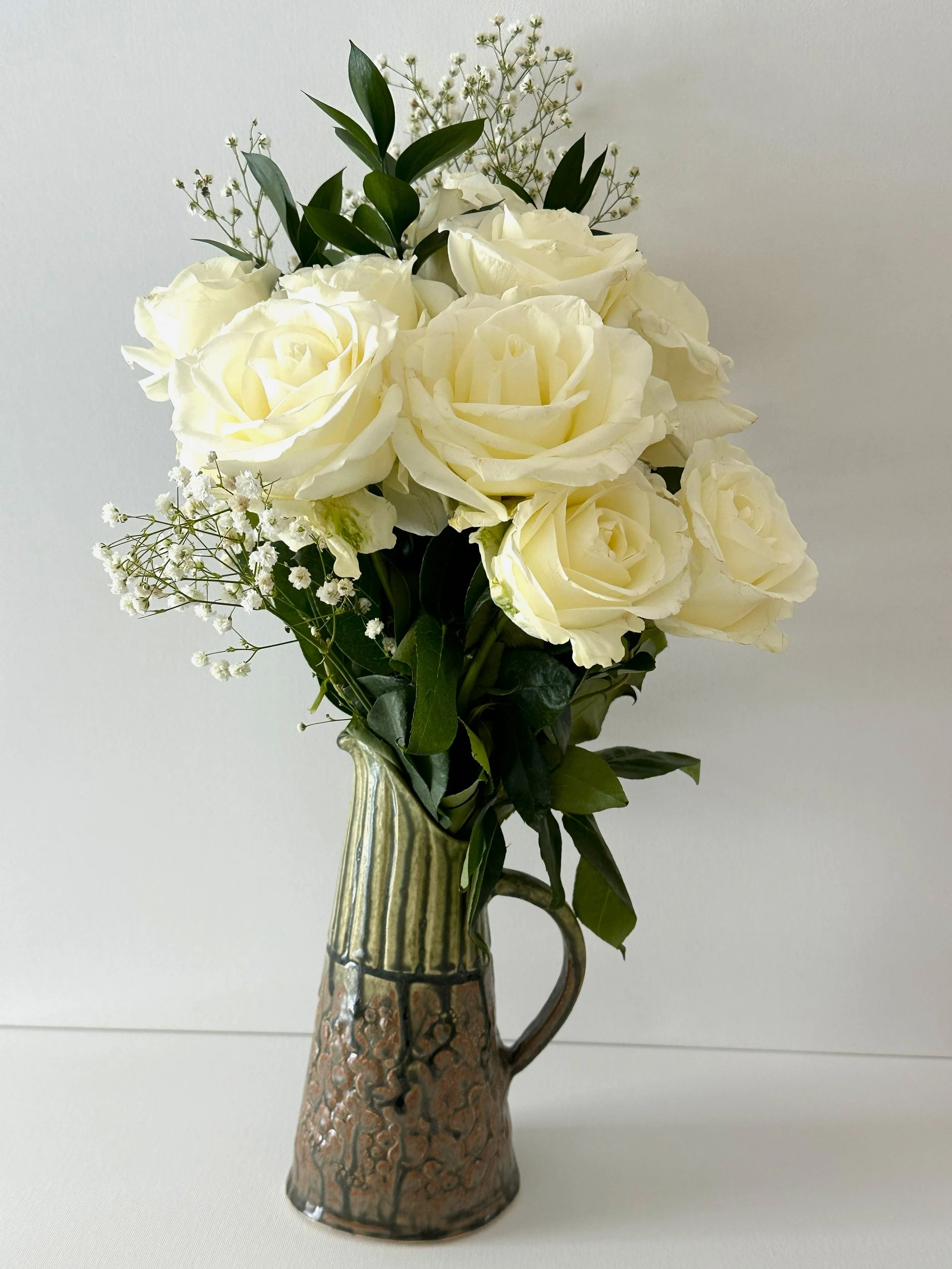 This lovely porcelain clay pitcher can also be used as a flower vase. It is finished with a Santorini Ash glaze.