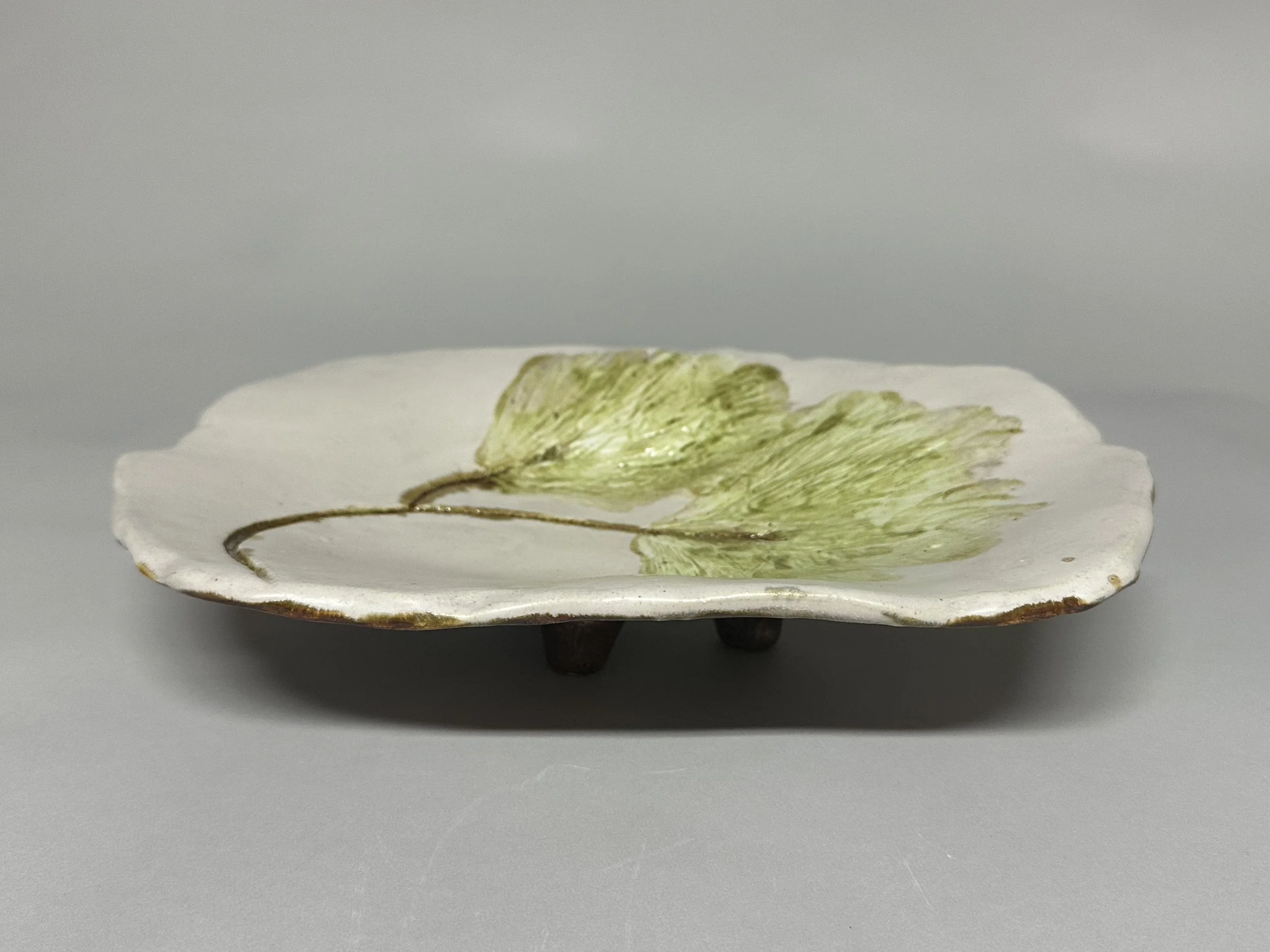 A pedestal hand‑crafted piece featuring a Northern Michigan white pine design, finished in soft green and oatmeal tones to represent Michigan, with a copper‑glazed underside for a warm contrast.