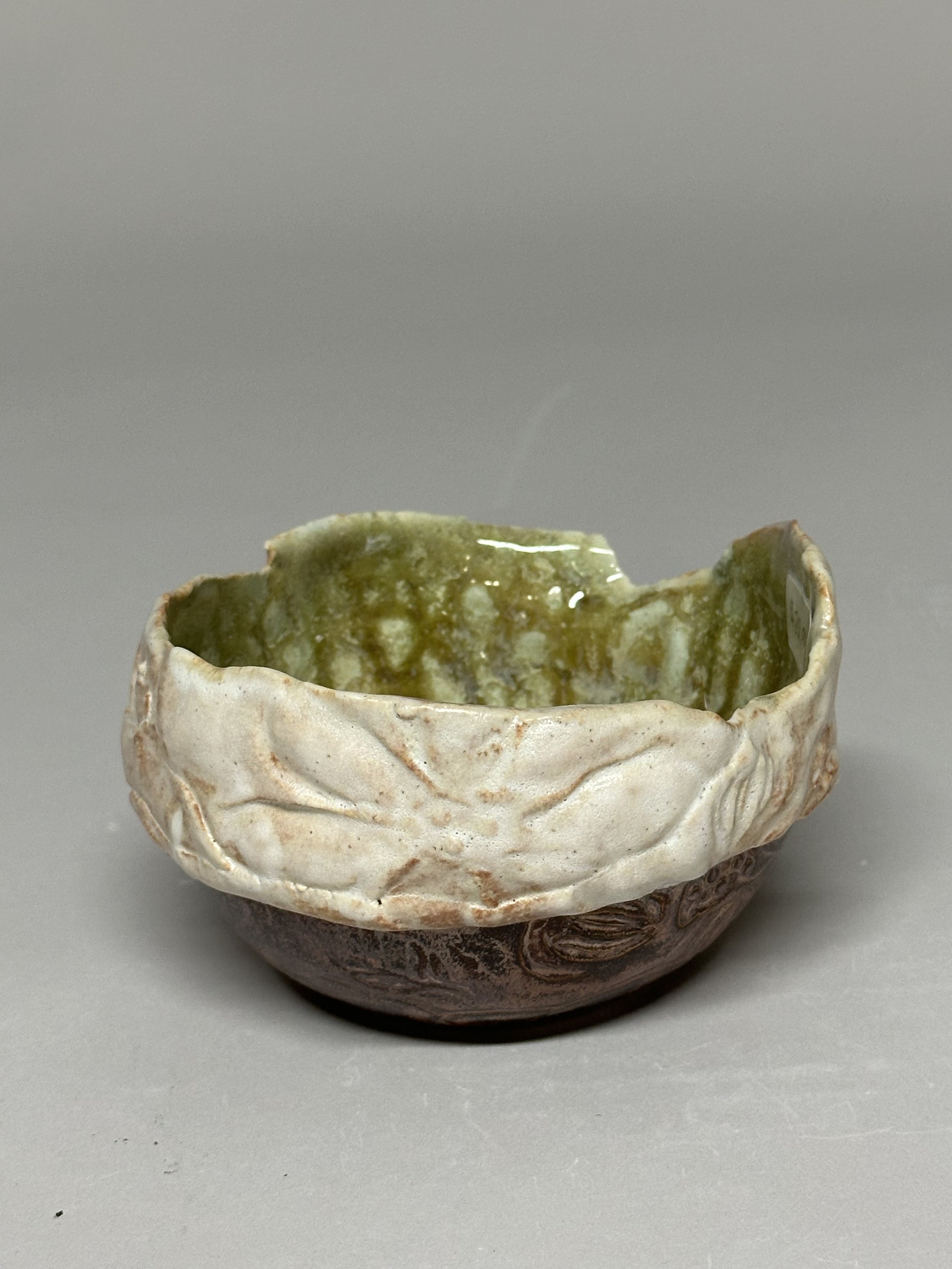 A medium‑sized layered bowl, hand built with flower stamps that celebrate Michigan’s natural beauty. The exterior is finished in warm copper and Shino oatmeal glazes, while the inside holds eight layered glazes that echo the deep, rich tones of the U