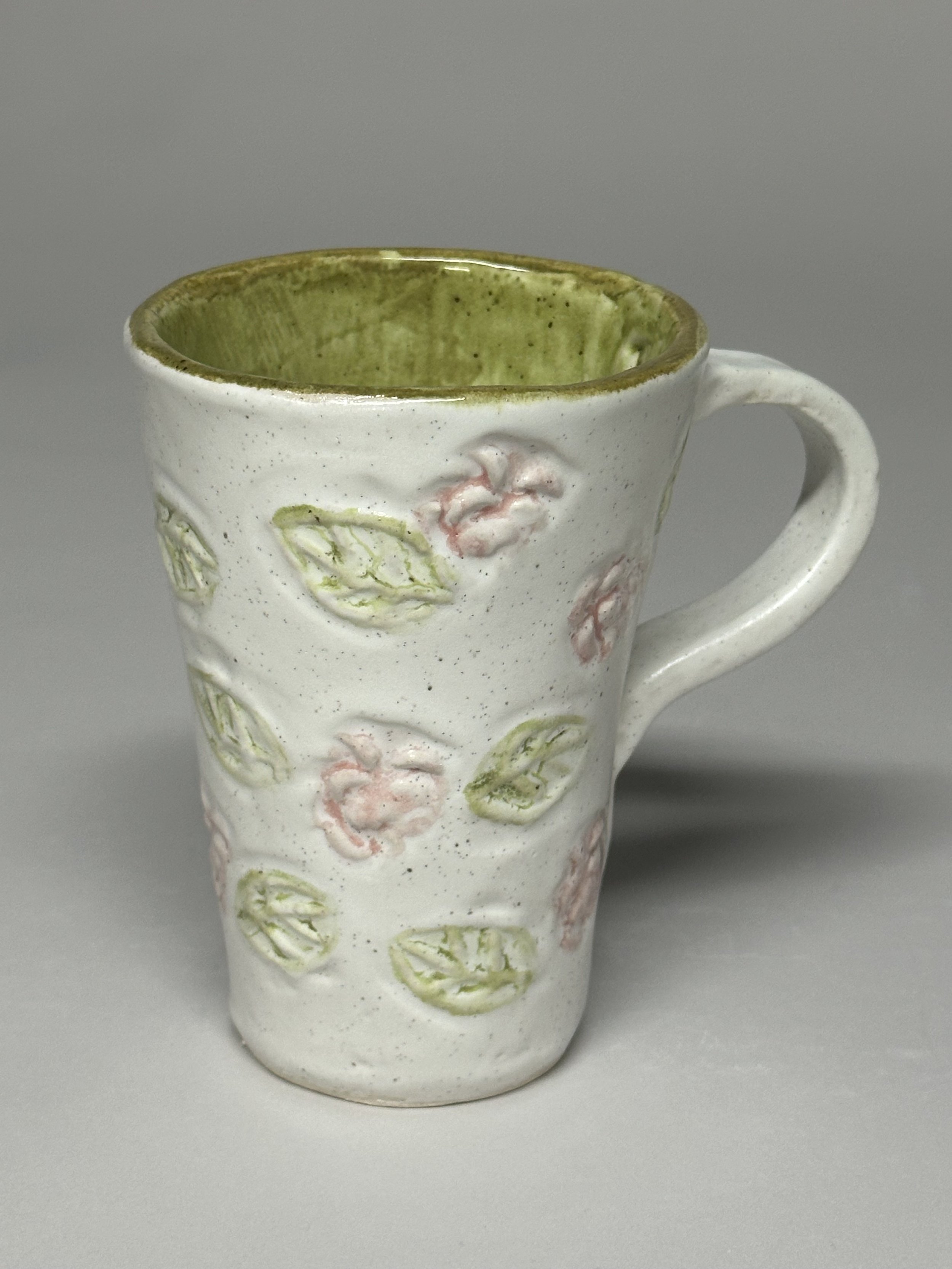 A soft spring green glaze with handmade rose and leaf stamps, creating a gentle, garden‑inspired finish. SOLD!