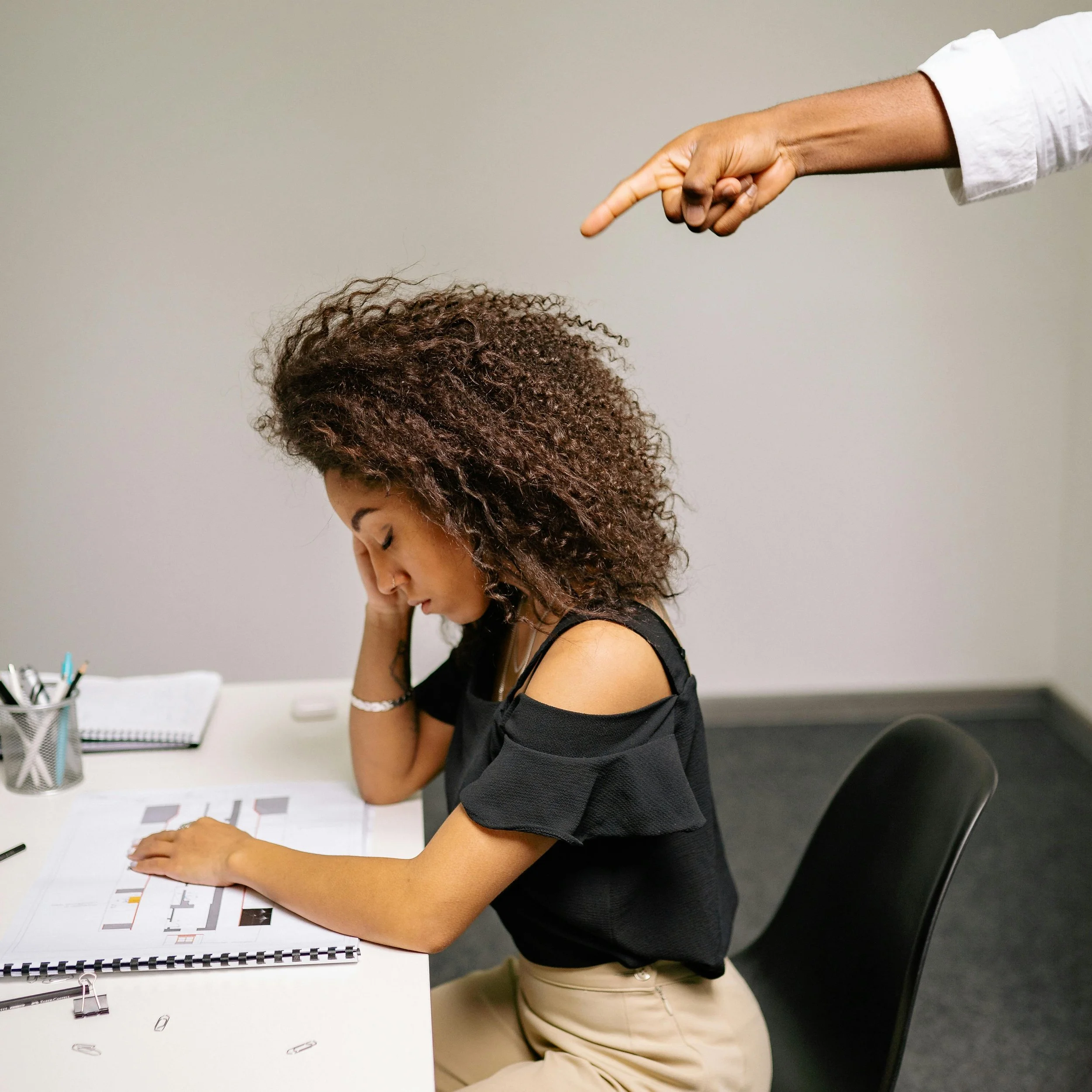 An image showing a female employee is being insulted because of her race.