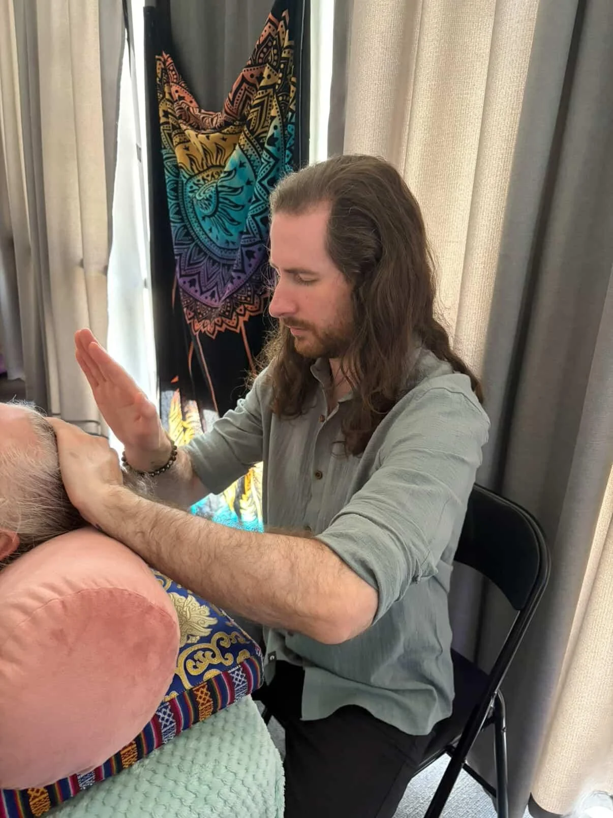 Reiki Master giving a Traditional Usui Reiki session with a client. Channeling Reiki healing energy into the Crown Chakra