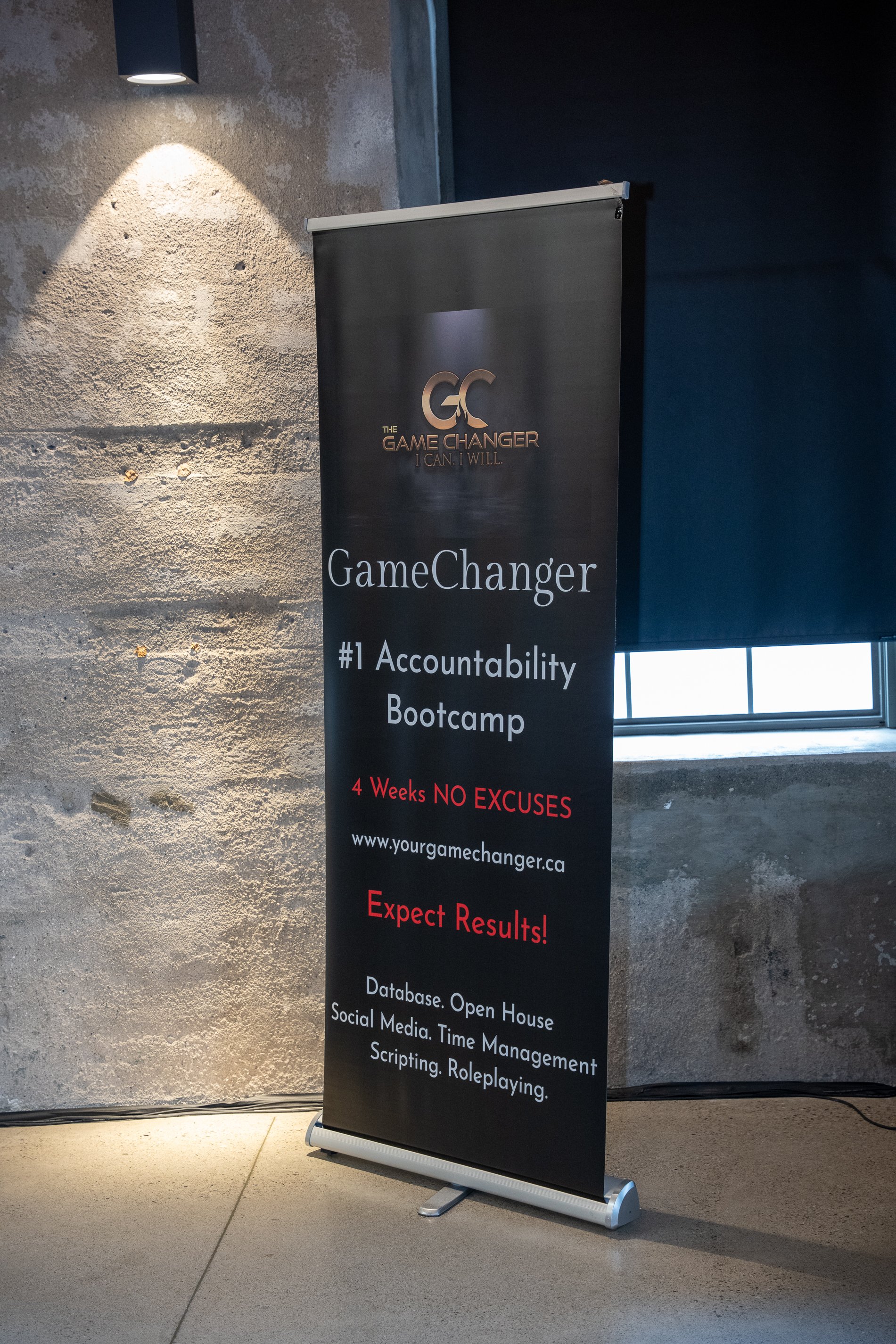 A black vertical banner advertising the GameChanger accountability bootcamp. The banner includes the text 'The Game Changer I CAN. I WILL.', '#1 Accountability Bootcamp', '4 Weeks NO EXCUSES', 'www.yourgamechanger.ca', 'Expect Results!', and details 
