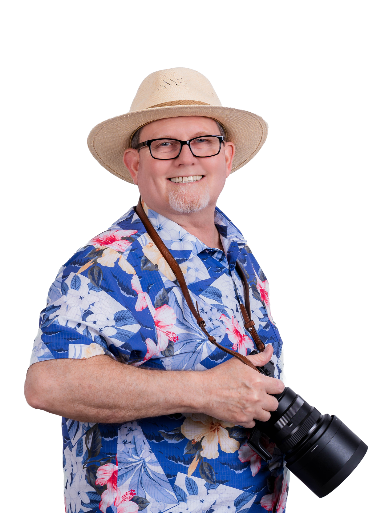A smiling man in a tropical shirt and wide-brimmed hat holding a camera.