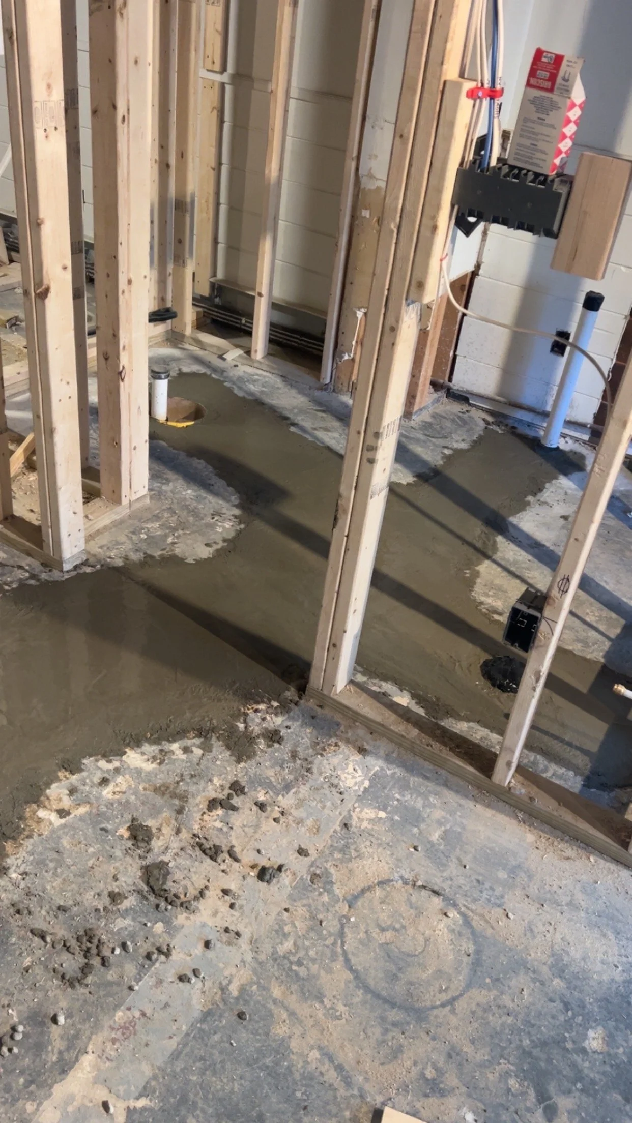Basement bathroom rough-in with underground drains and fresh concrete