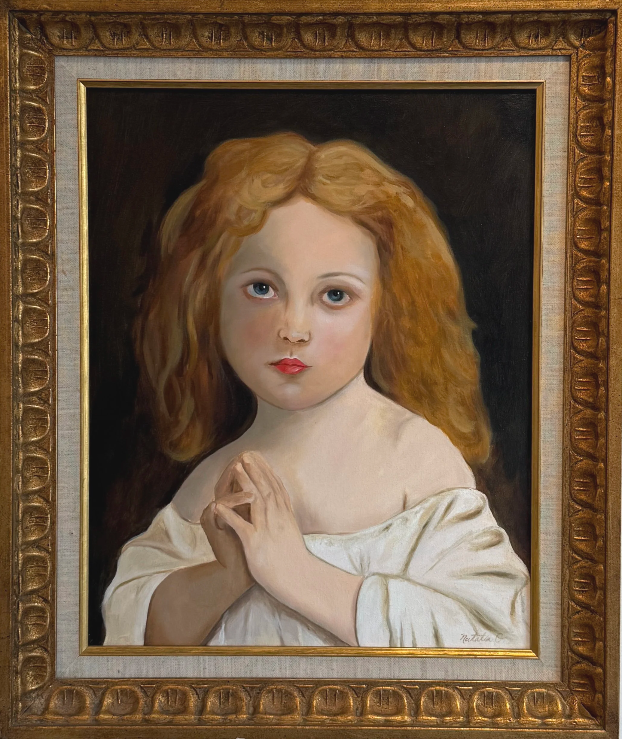 Painting of a young girl with red hair, blue eyes, and fair skin, wearing a white garment, set in an ornate gold frame.