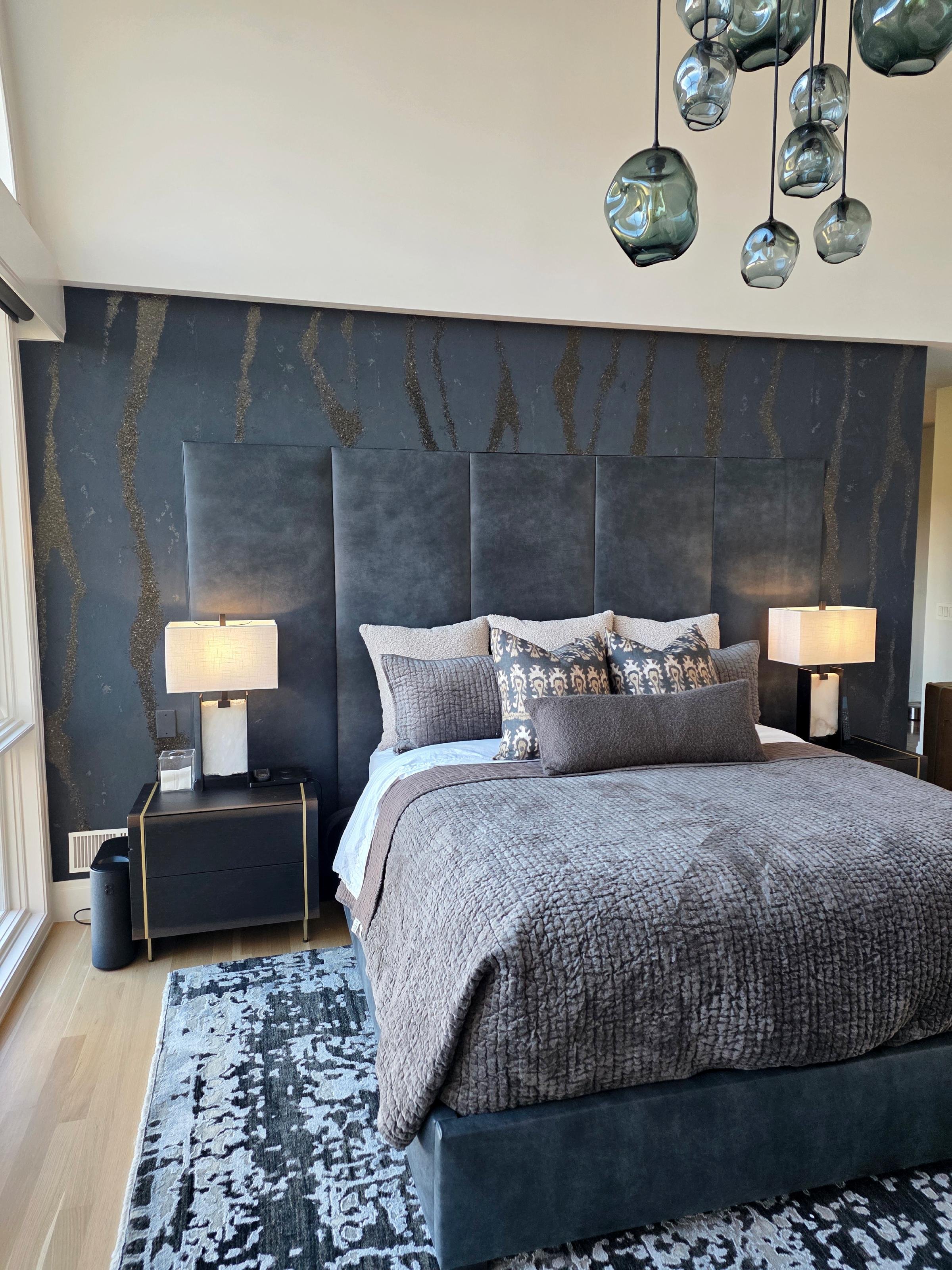 Custom upholstered wallpaper accent wall behind bed in Denver bedroom