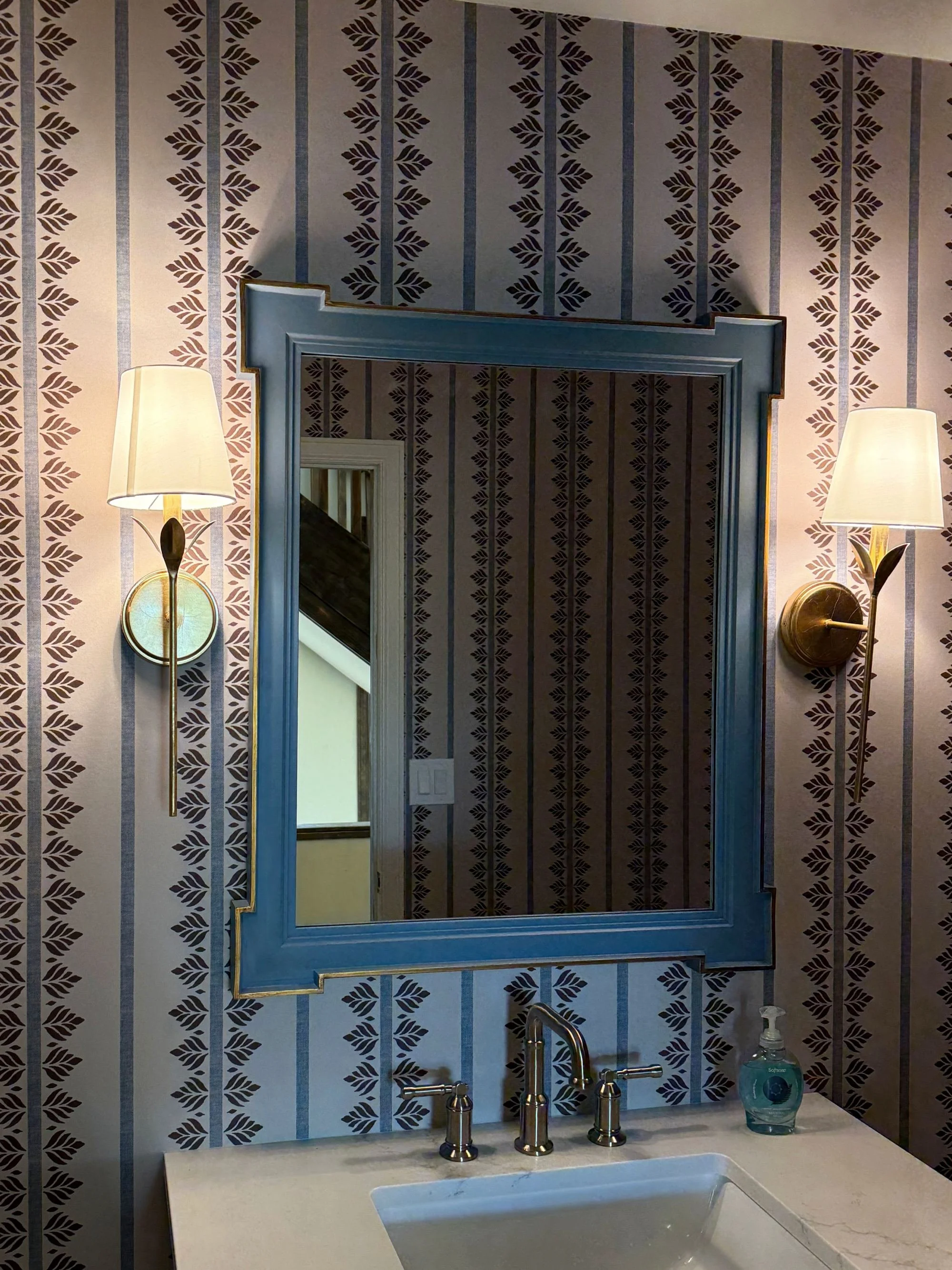 Powder room wallpaper installation with framed mirror and wall sconces in Denver, CO