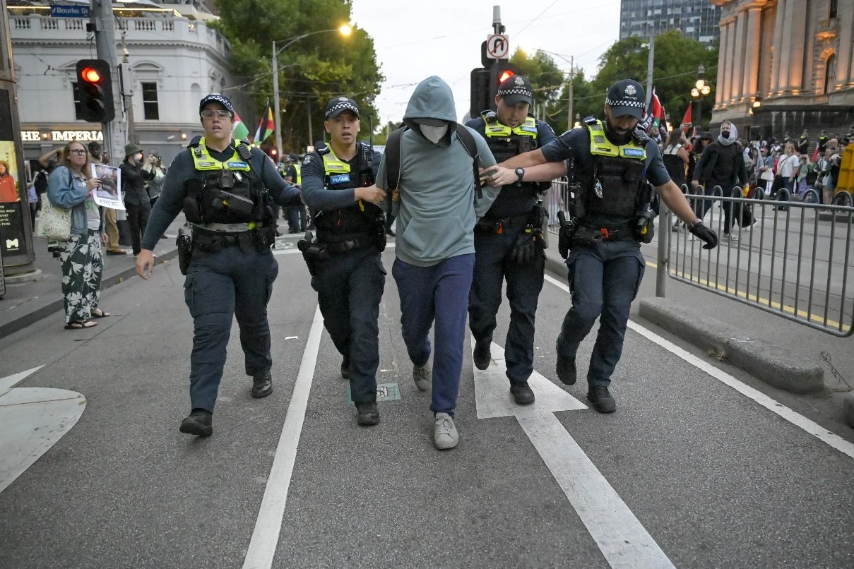 This documentary photograph was taken during a pro-Palestine march through Melbourne’s CBD, showing public protest, political symbolism, and everyday human moments within an urban demonstration. Photo by Farhad Rajabali