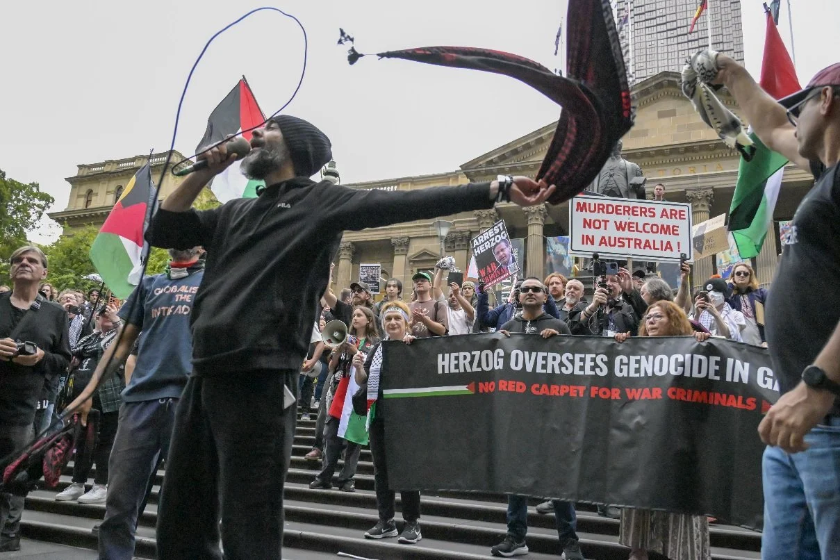 This documentary photograph was taken during a pro-Palestine march through Melbourne’s CBD, showing public protest, political symbolism, and everyday human moments within an urban demonstration. Photo by Farhad Rajabali