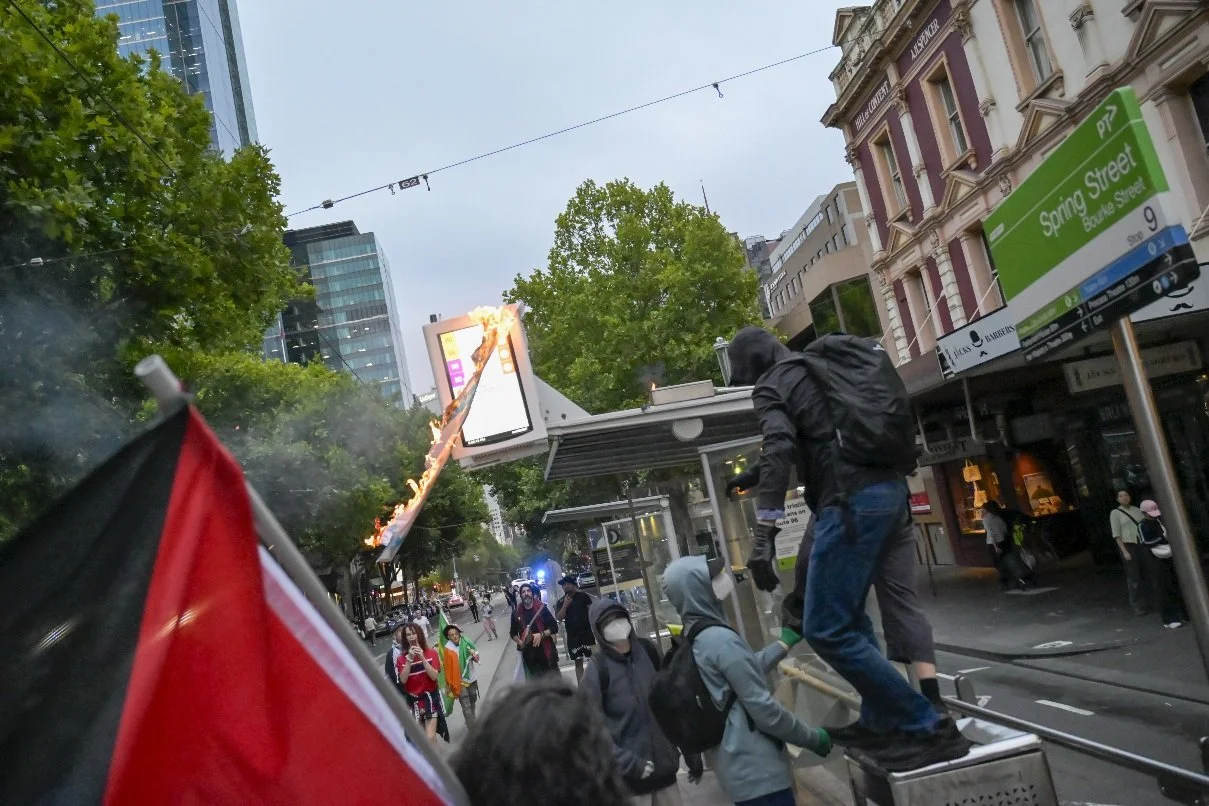 This documentary photograph was taken during a pro-Palestine march through Melbourne’s CBD, showing public protest, political symbolism, and everyday human moments within an urban demonstration. Photo by Farhad Rajabali