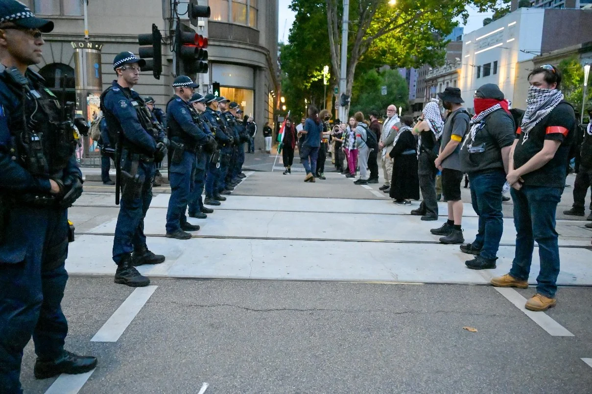 This documentary photograph was taken during a pro-Palestine march through Melbourne’s CBD, showing public protest, political symbolism, and everyday human moments within an urban demonstration. Photo by Farhad Rajabali