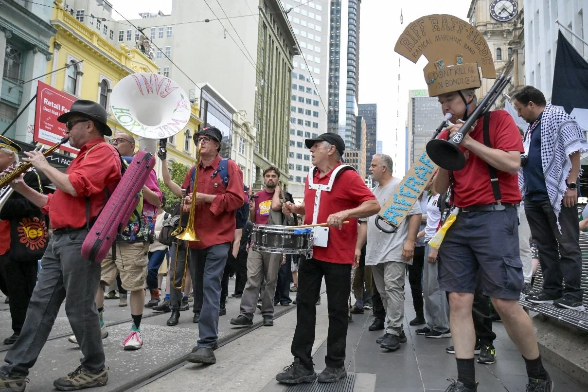 This documentary photograph was taken during a pro-Palestine march through Melbourne’s CBD, showing public protest, political symbolism, and everyday human moments within an urban demonstration. Photo by Farhad Rajabali