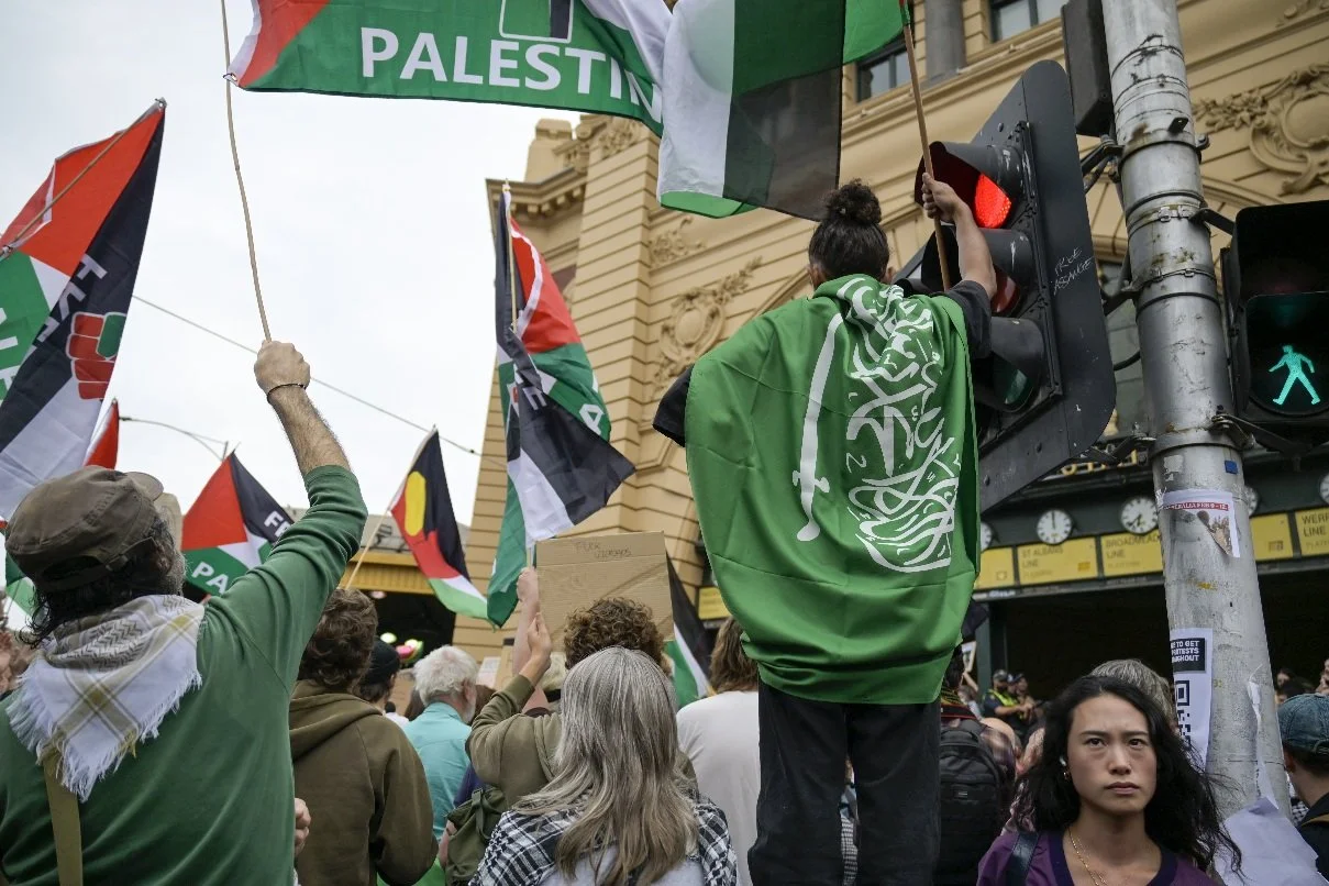 This documentary photograph was taken during a pro-Palestine march through Melbourne’s CBD, showing public protest, political symbolism, and everyday human moments within an urban demonstration. Photo by Farhad Rajabali