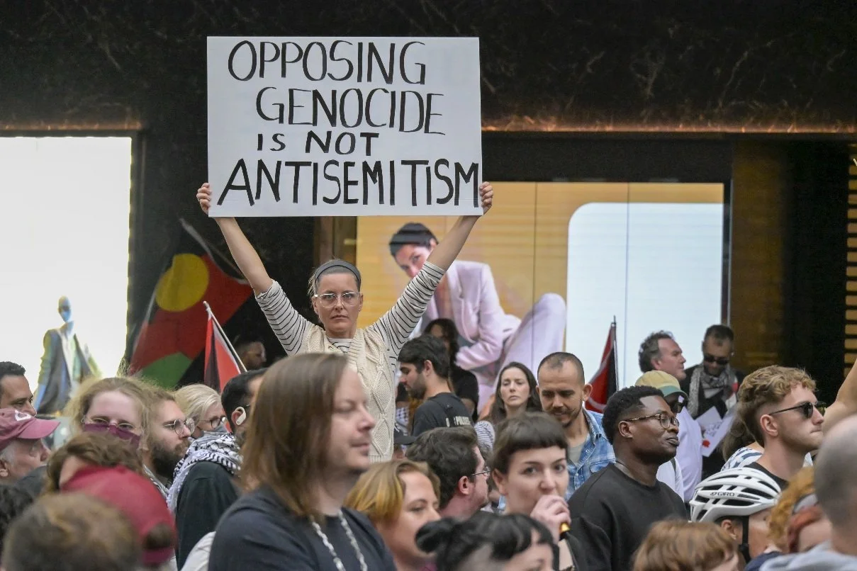 This documentary photograph was taken during a pro-Palestine march through Melbourne’s CBD, showing public protest, political symbolism, and everyday human moments within an urban demonstration. Photo by Farhad Rajabali