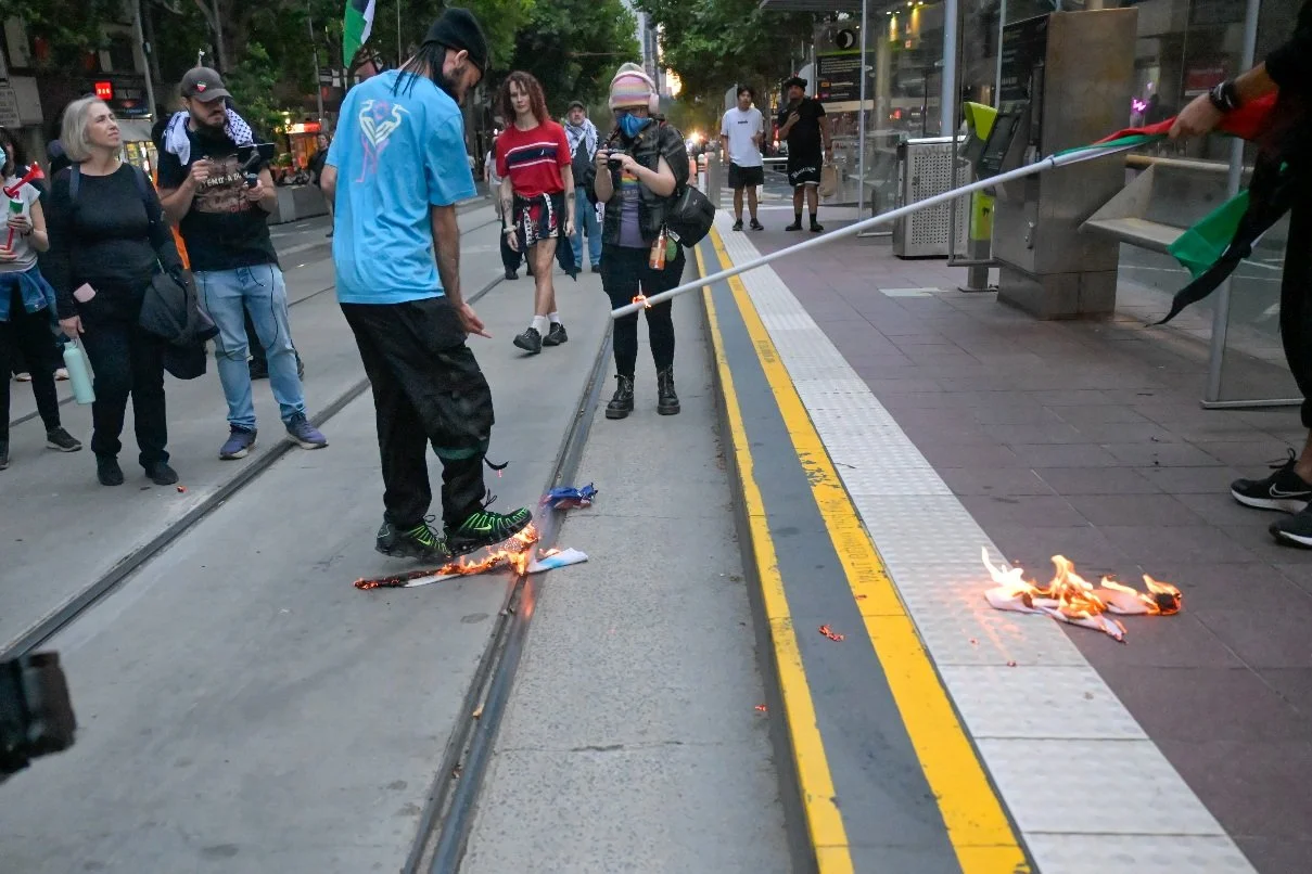 This documentary photograph was taken during a pro-Palestine march through Melbourne’s CBD, showing public protest, political symbolism, and everyday human moments within an urban demonstration. Photo by Farhad Rajabali