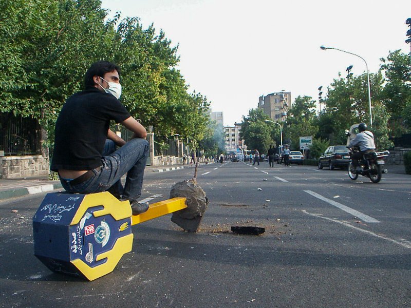 Editorial photograph from the Green Movement protests in Iran during 2009–2010, documenting public demonstrations, civic resistance, and everyday life under heightened security conditions. Part of a long-form documentary project by photographer Farha