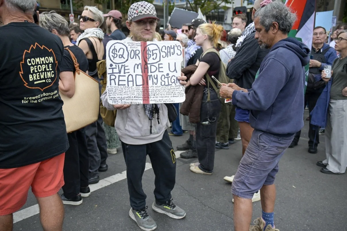 This documentary photograph was taken during a pro-Palestine march through Melbourne’s CBD, showing public protest, political symbolism, and everyday human moments within an urban demonstration. Photo by Farhad Rajabali