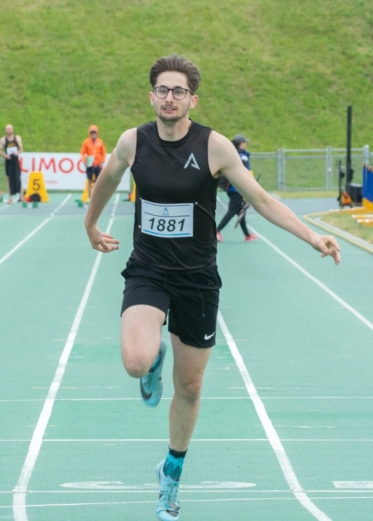 Un homme court sur une piste d'athlétisme lors d'une compétition.