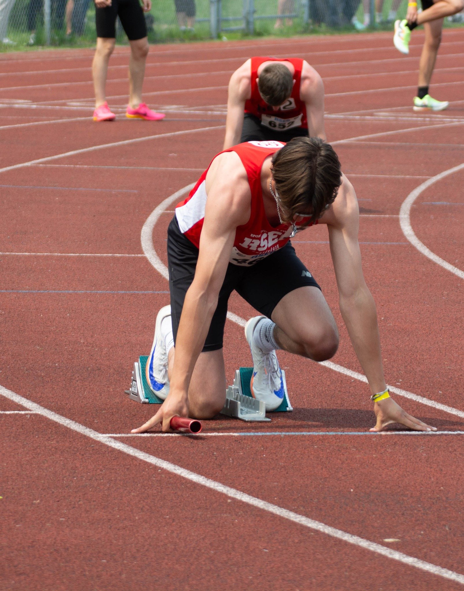 Athlète en position de départ pour une course sur une piste d'athlétisme .
