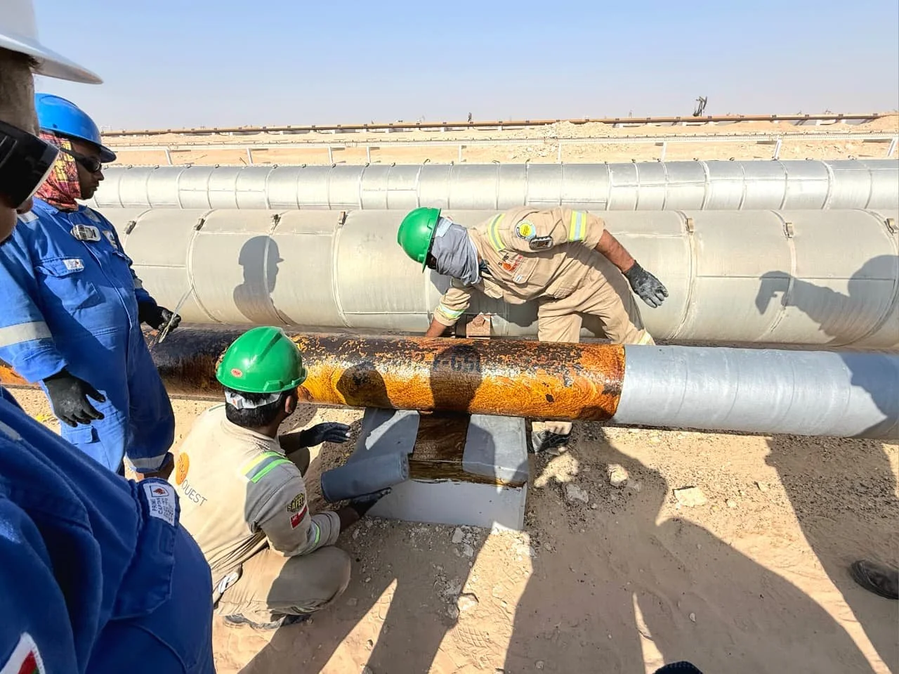 workers protecting pipine in oman using the trenton anti corrosion wax tape wrap systems