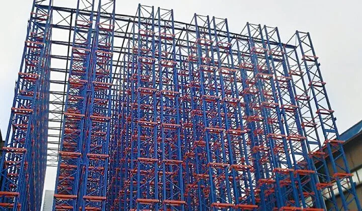 A large rack-supported system with blue and red metal beams, used for storing a high density of pallets.