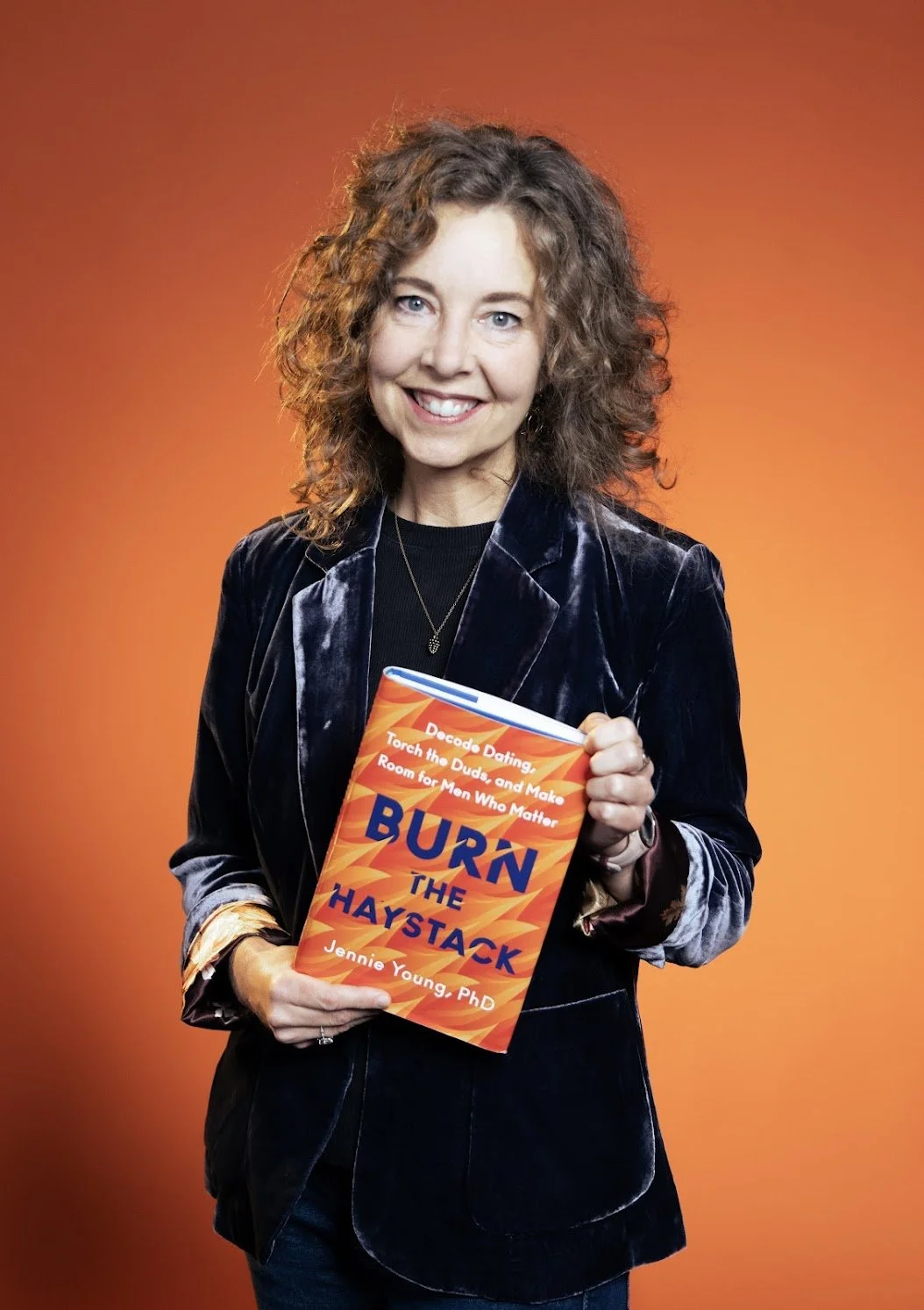 A picure of Jennie Young holding her book Burn the Haystack.