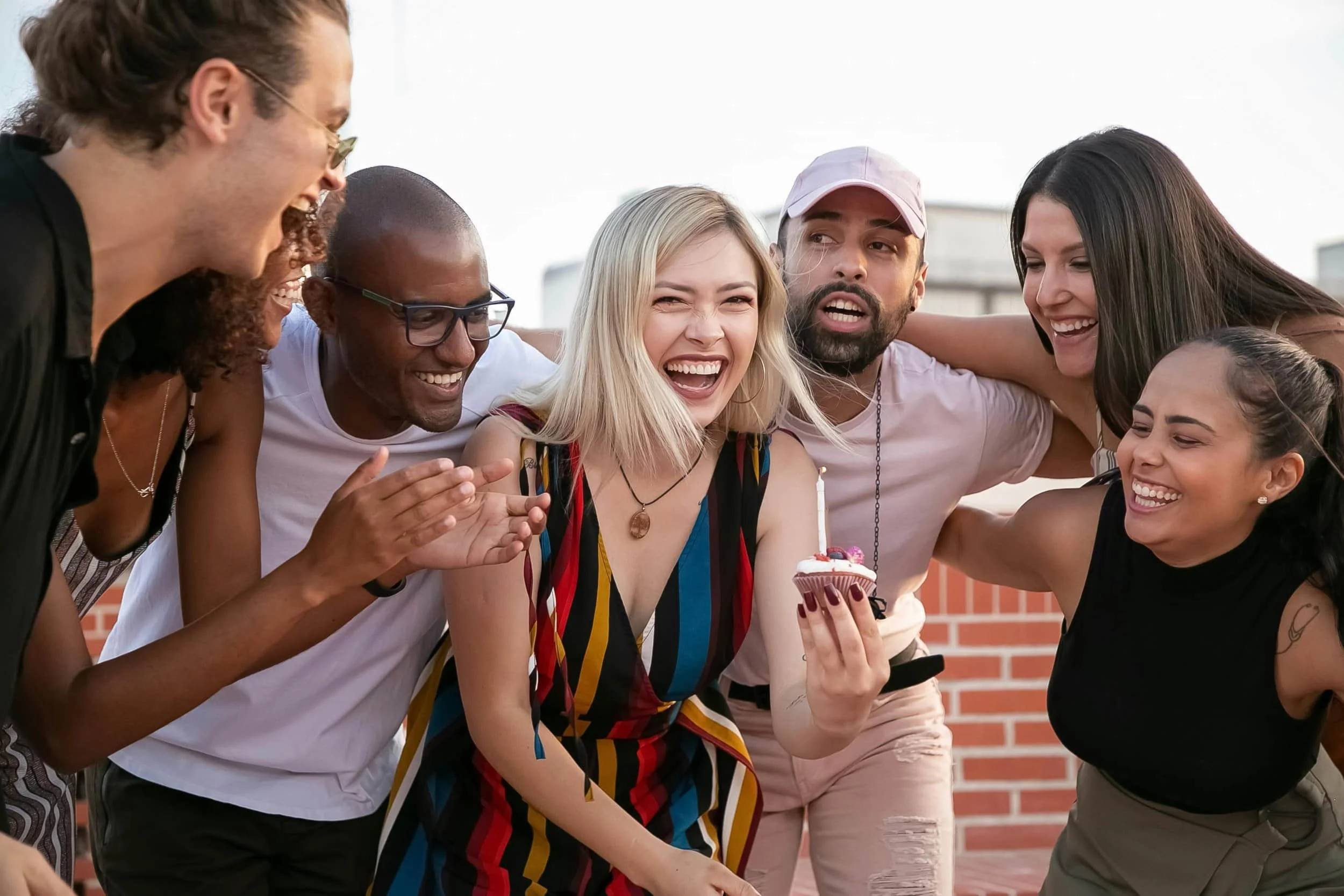 Group of friends smiling and hugging outdoors in a park