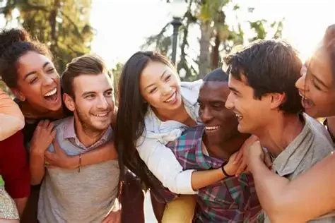 Group of friends smiling and hugging outdoors in a park