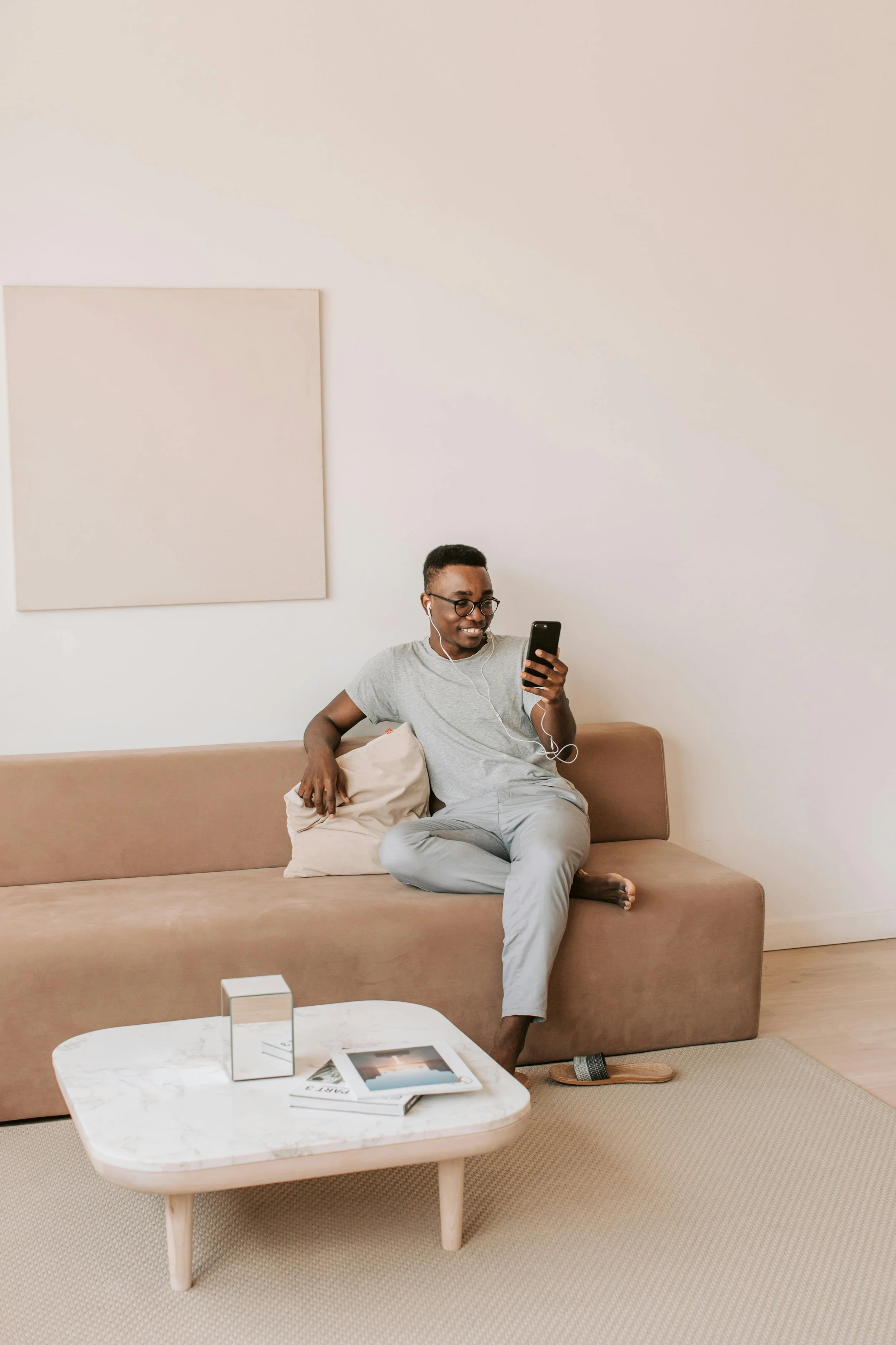Man sitting relaxed on a sofa looking at his phone representing anxiety treatment outcomes in New York City