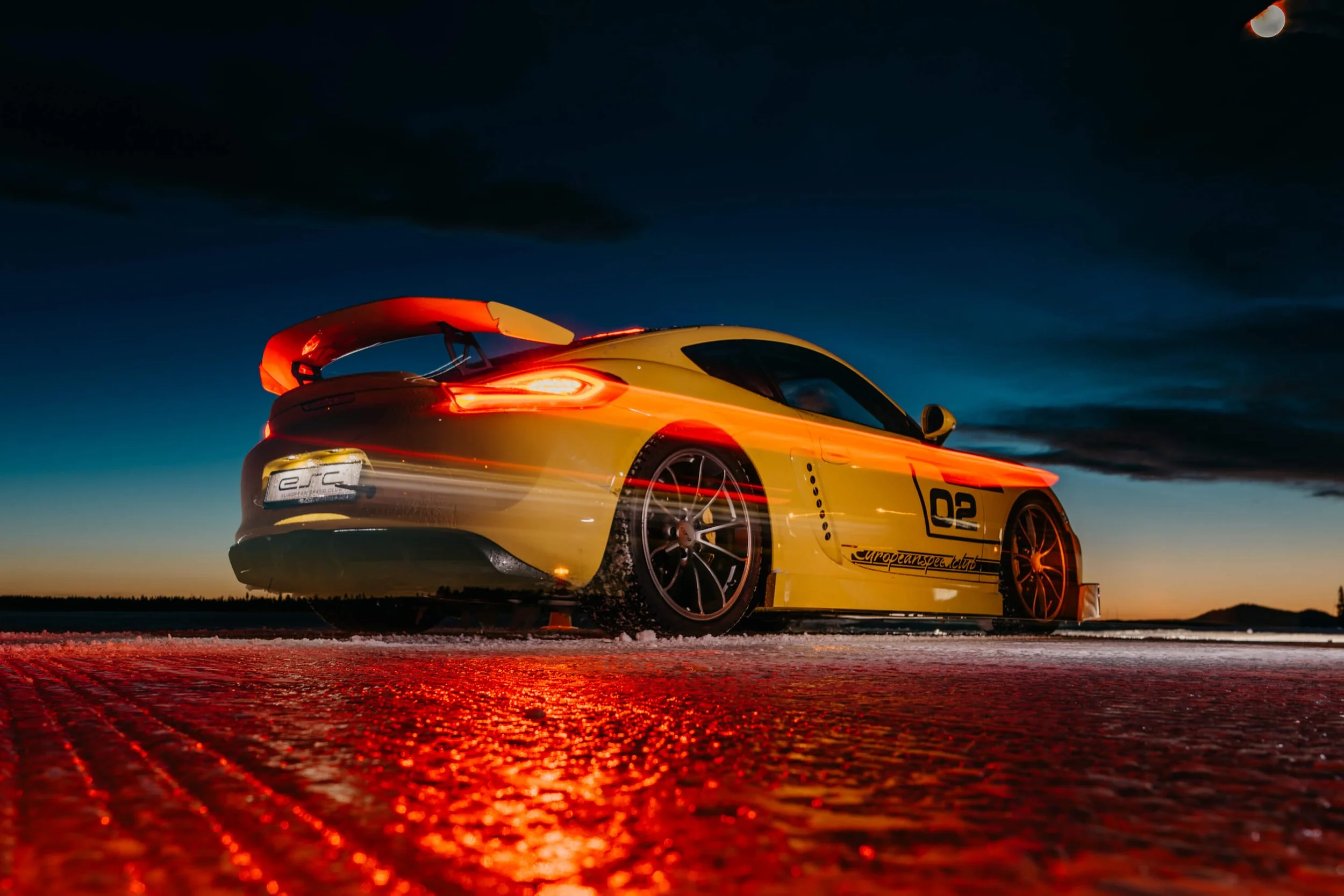 Long exposure of porsche rear with light trails leaving the starting line at night.