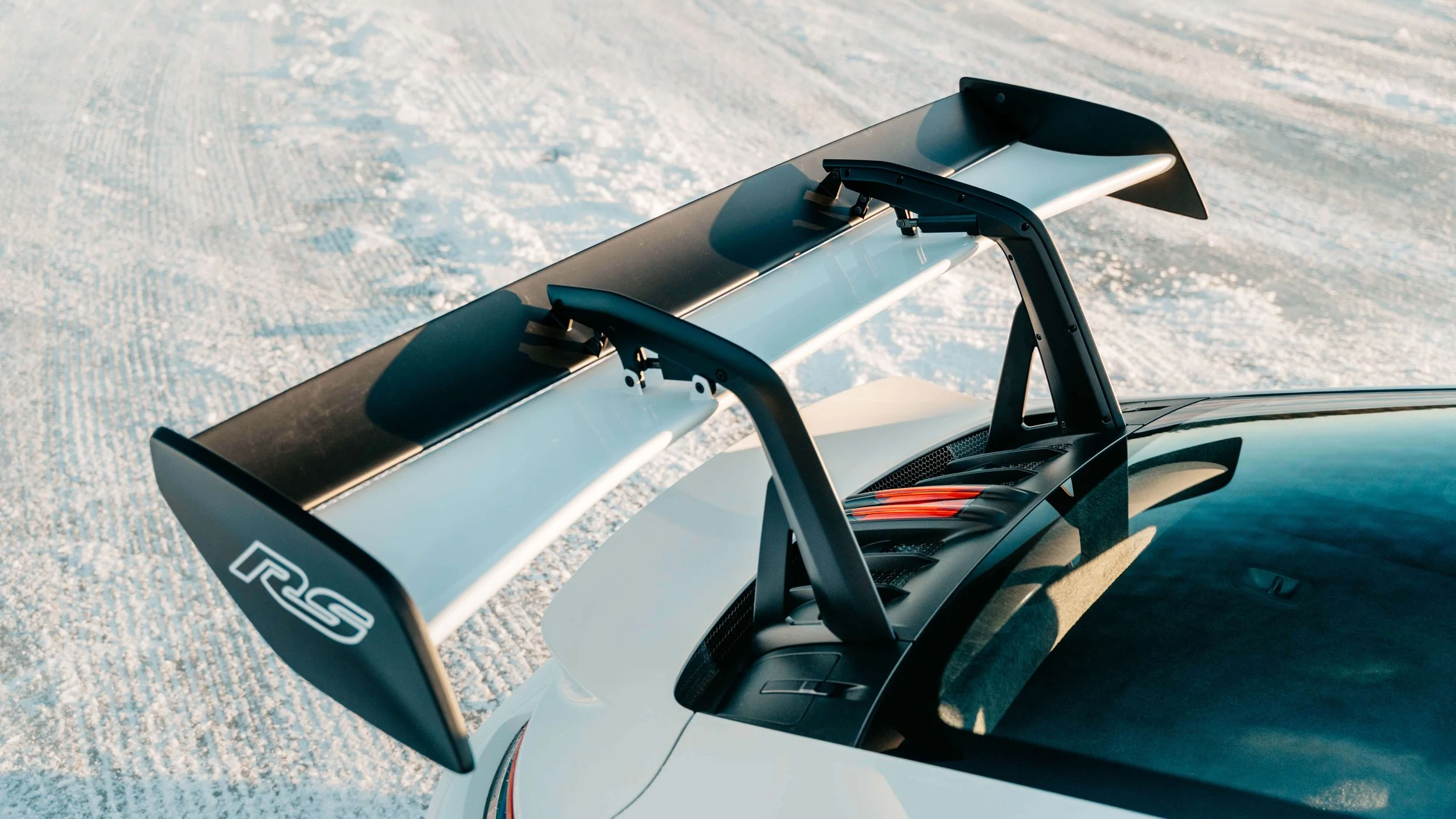 Top down view of Porsche GT3 RS wing while parked on frozen lake.