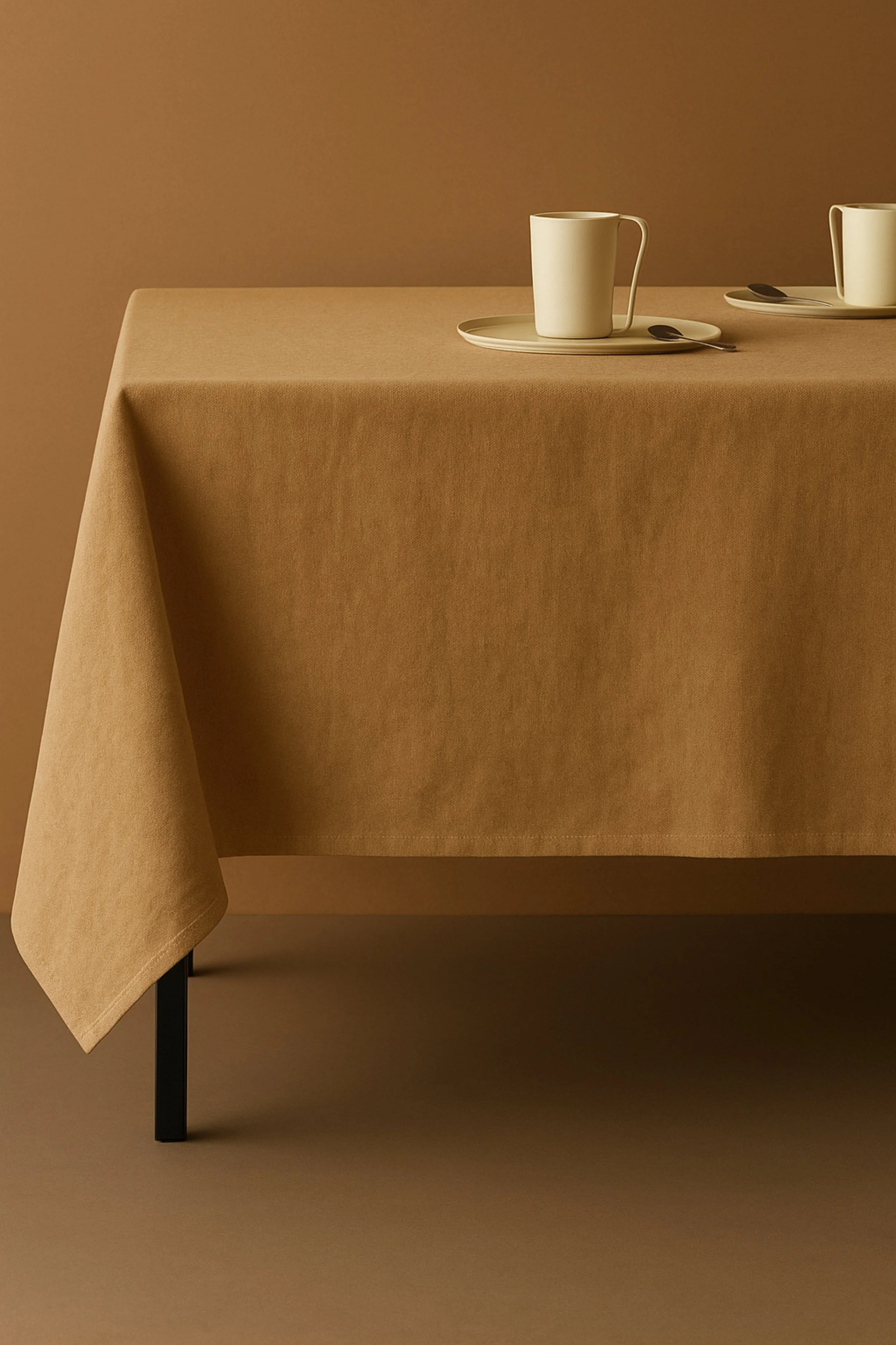 Two white mugs on beige plates with spoons on a brown tablecloth against a brown background.