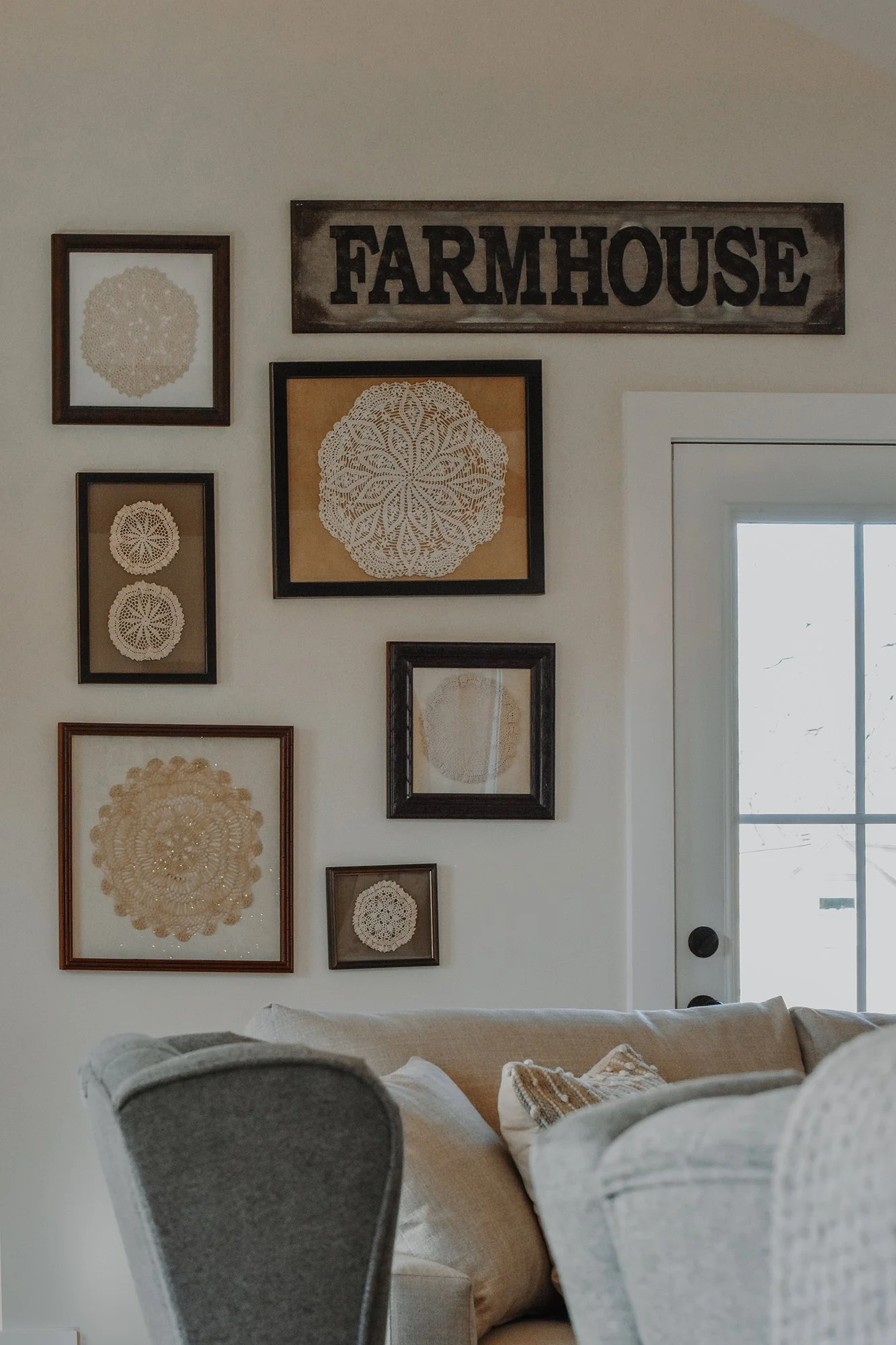 wall in restored farmhouse wilth antique framed doilies