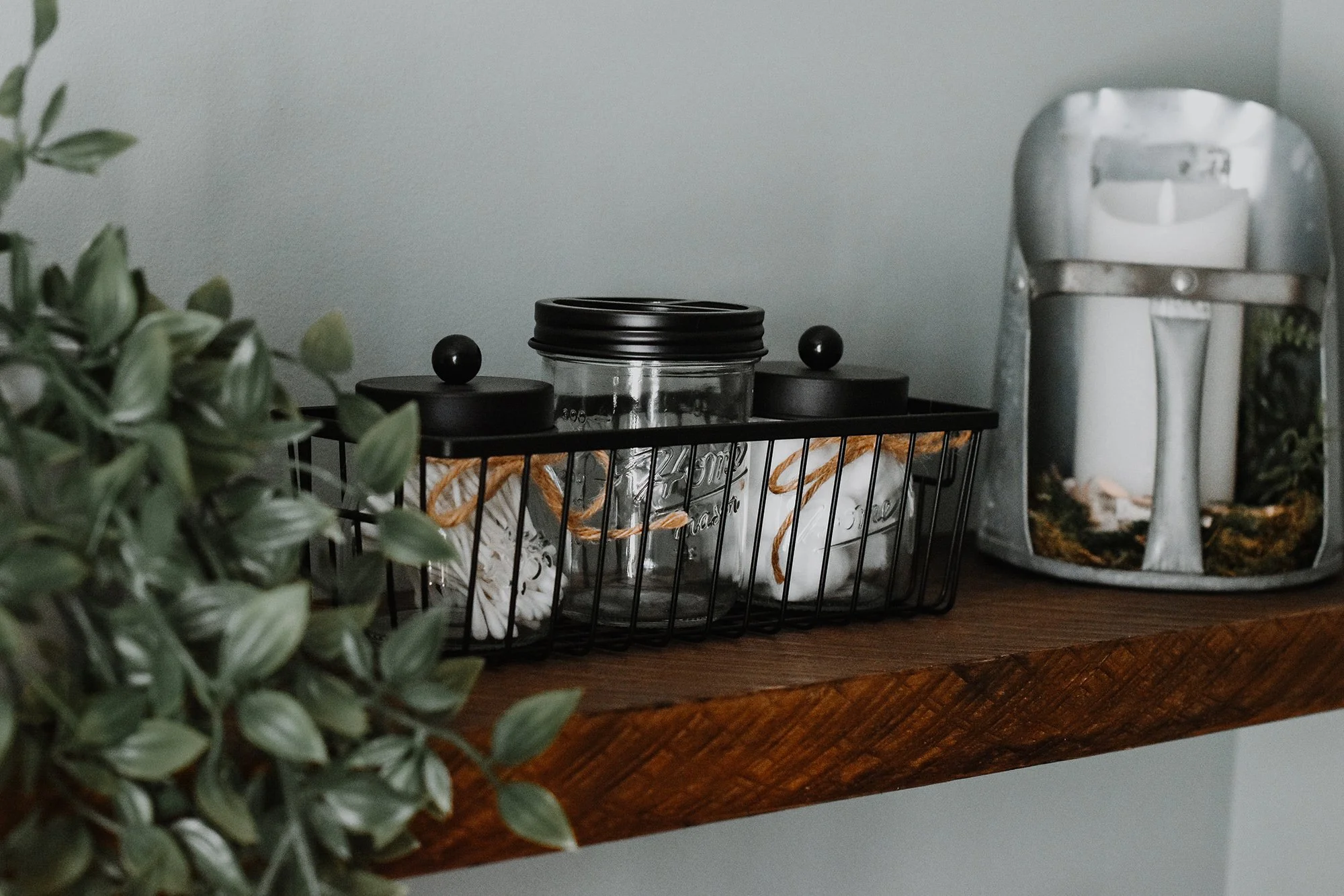 rustic modern farmhouse bathroom amenities, jar storage, floating shelf, candle, fake plant