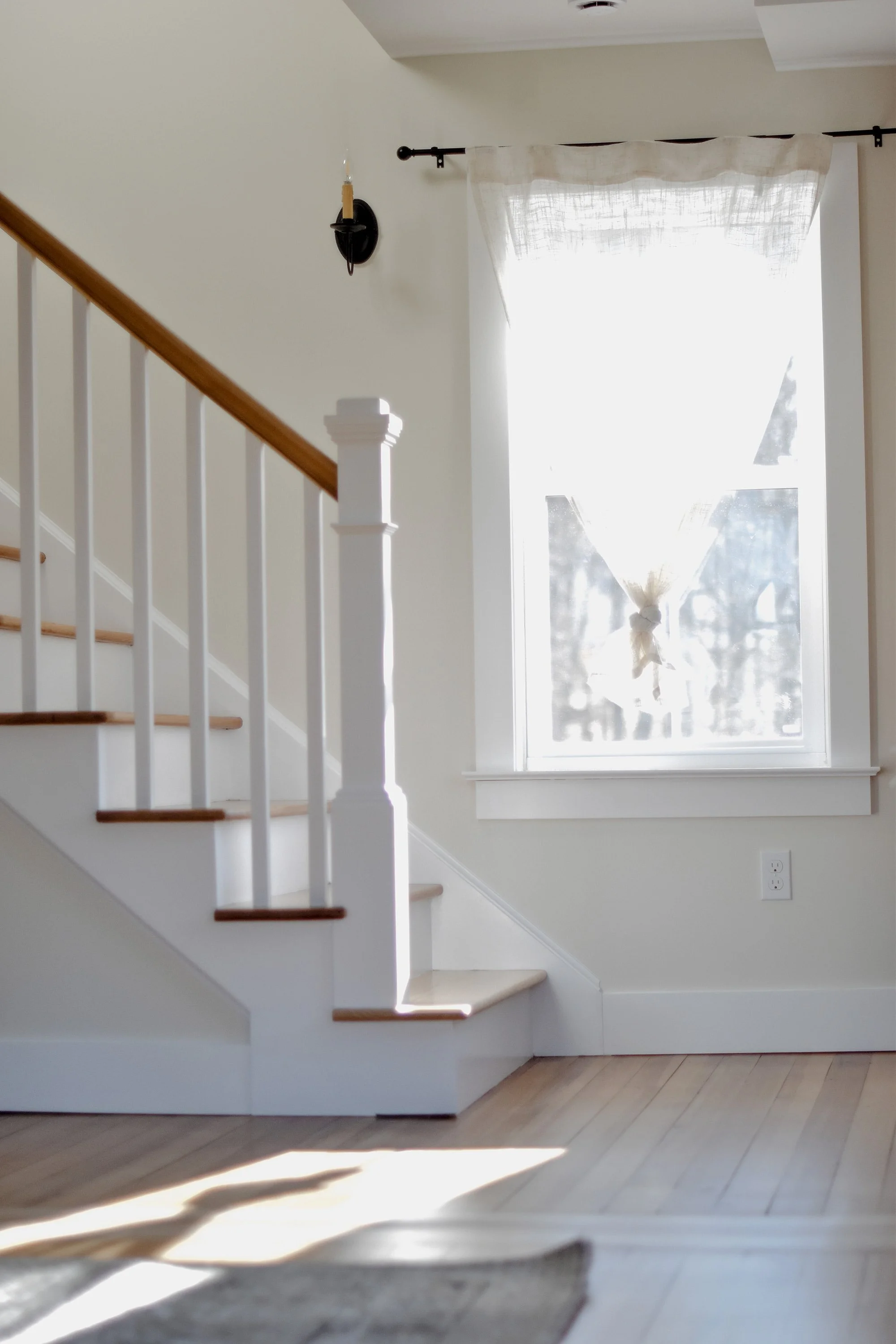 rustic modern farmhouse staircase, restored 1890 farmhouse floors, natural light pouring through farmhouse window and creamy linen curtains, candlestick light fixture 