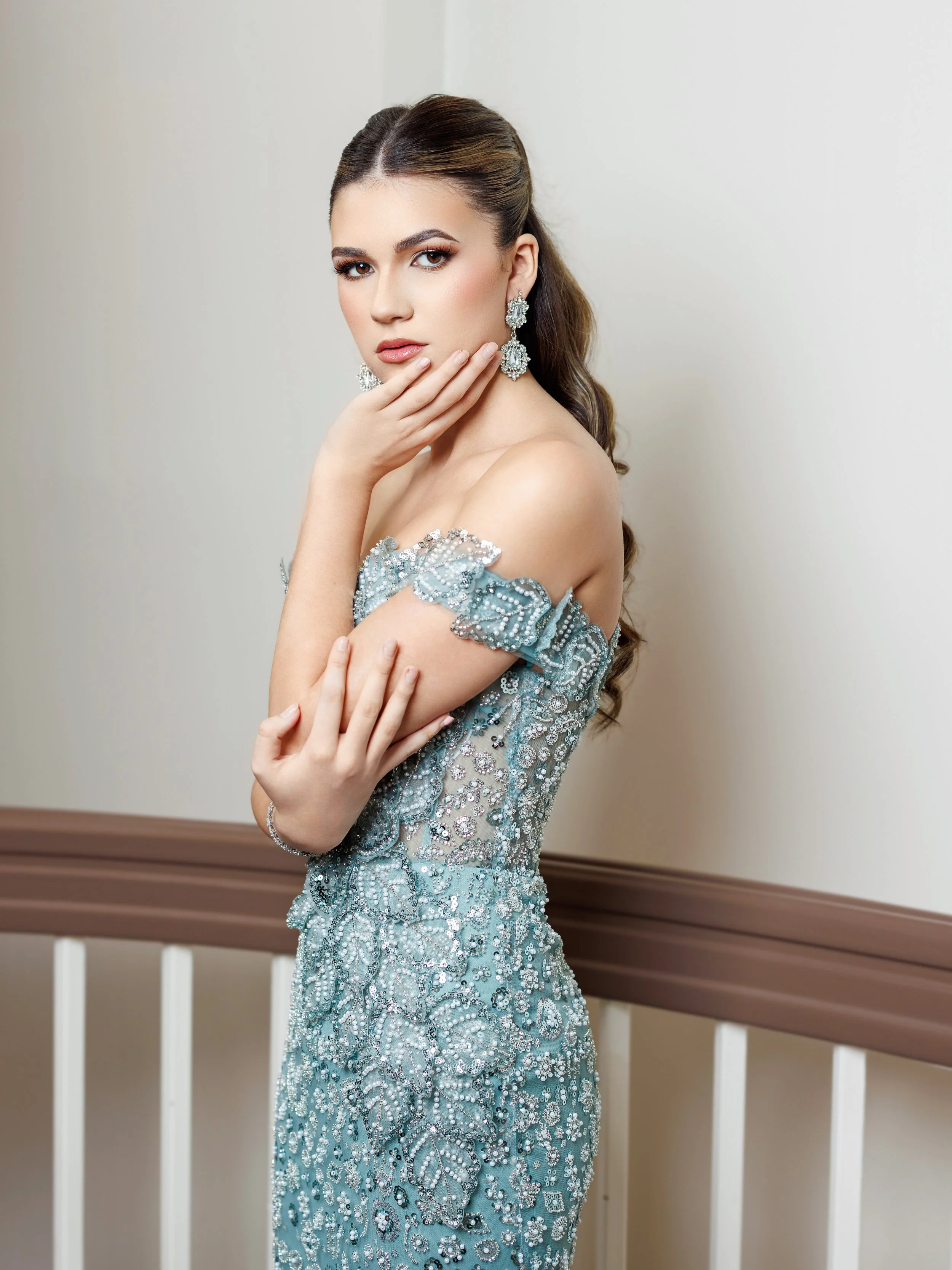 Woman in red ruffled dress sitting in a room with vintage curtains and a typewriter.