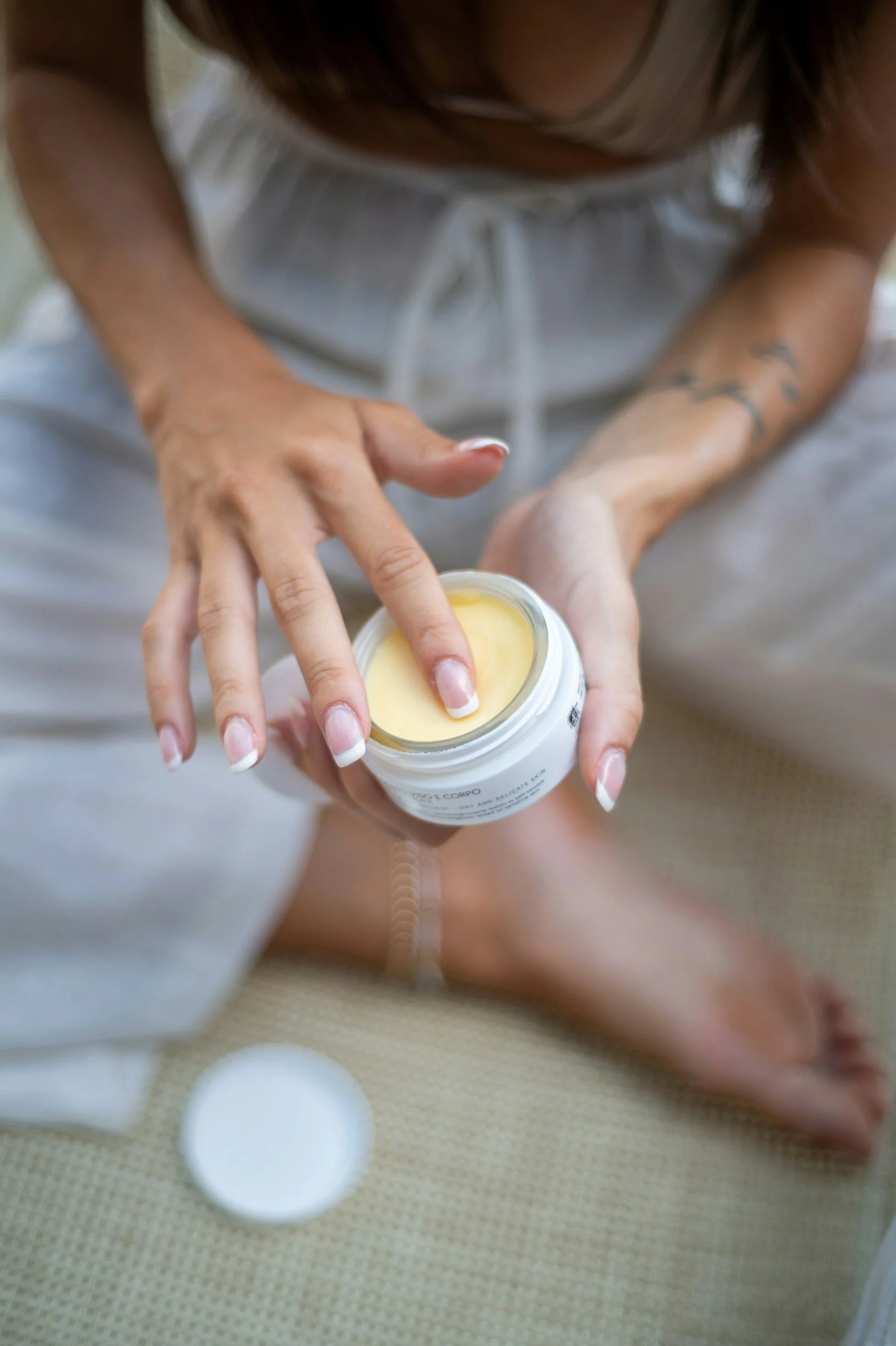 Persona aplicando crema en las piernas, vista desde arriba.