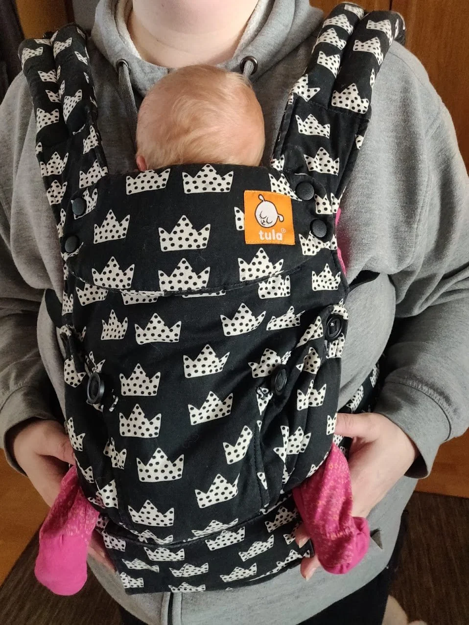 Henkilön keskivartalo, jonka peittää kantorepussa oleva vauva.