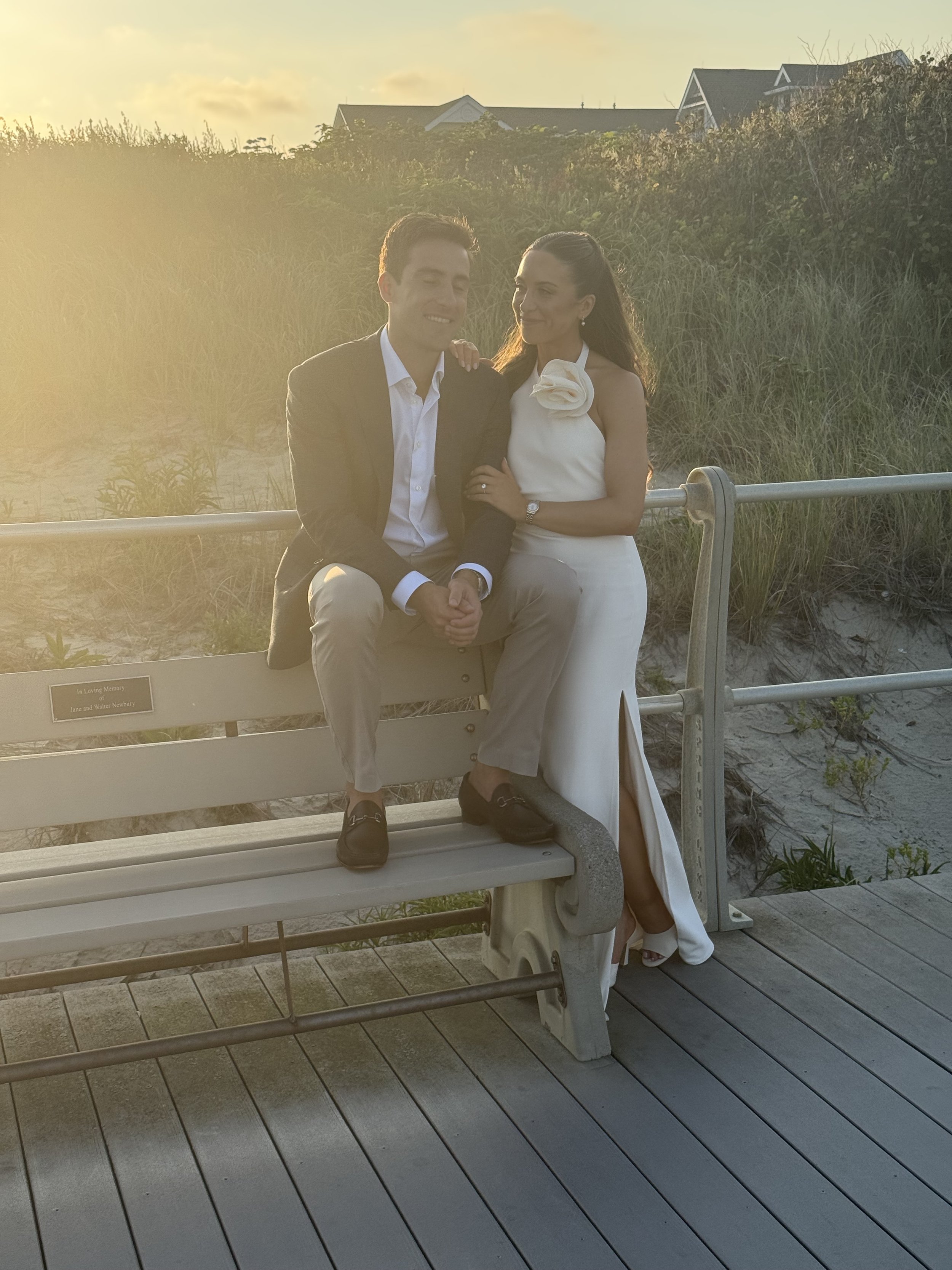 A couple ob a boardwalk in a sunset light smiling