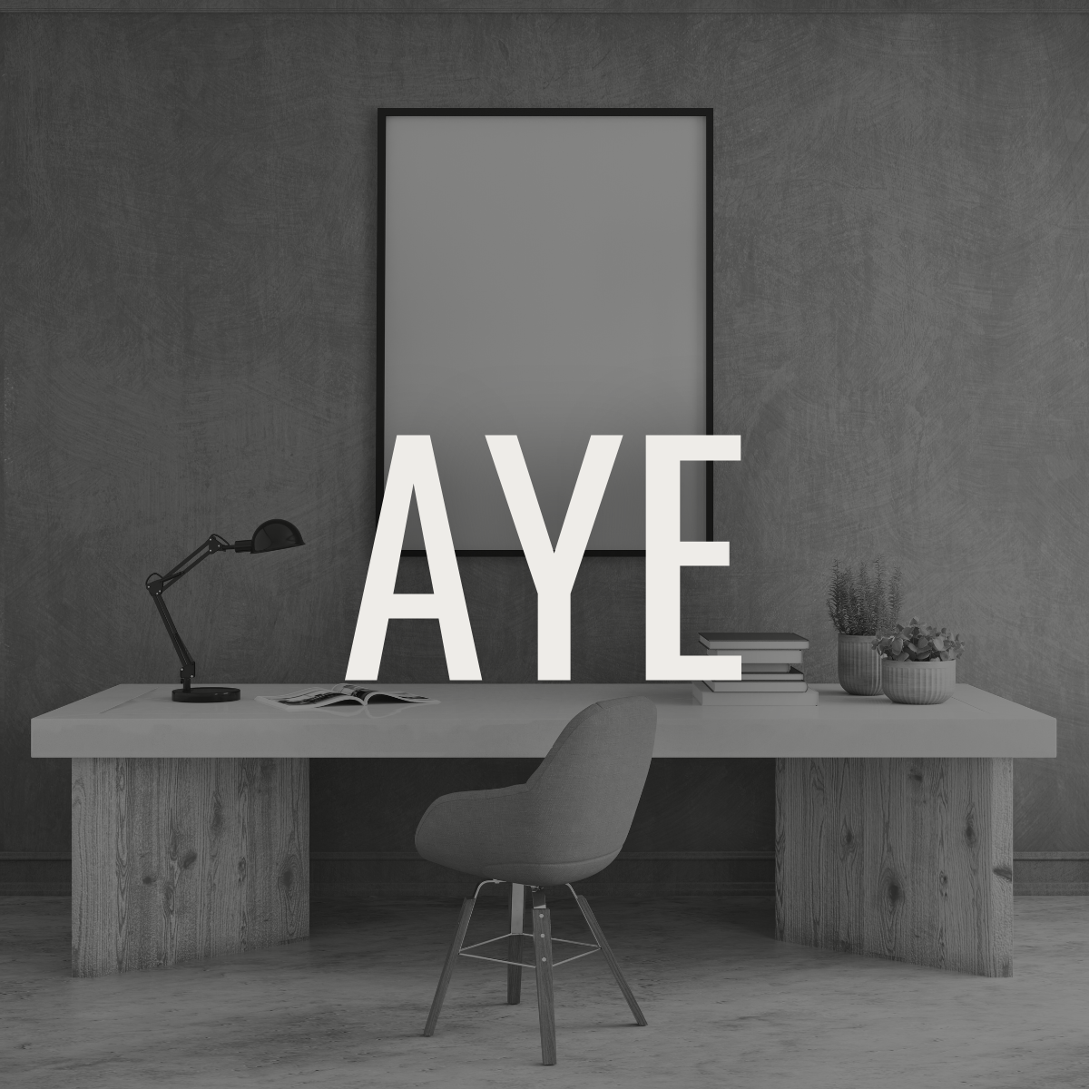 Minimalist office desk with large white letters spelling 'AYE' and a framed mirror or artwork behind. The desk has a black adjustable lamp, an open book, a stack of books, and two potted plants. Gray office chair in front, gray textured wall background.
