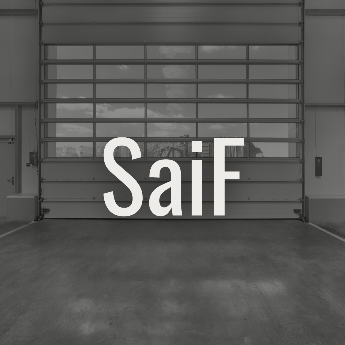 A gray industrial garage door with the word 'SaiF' written across it in large white letters.