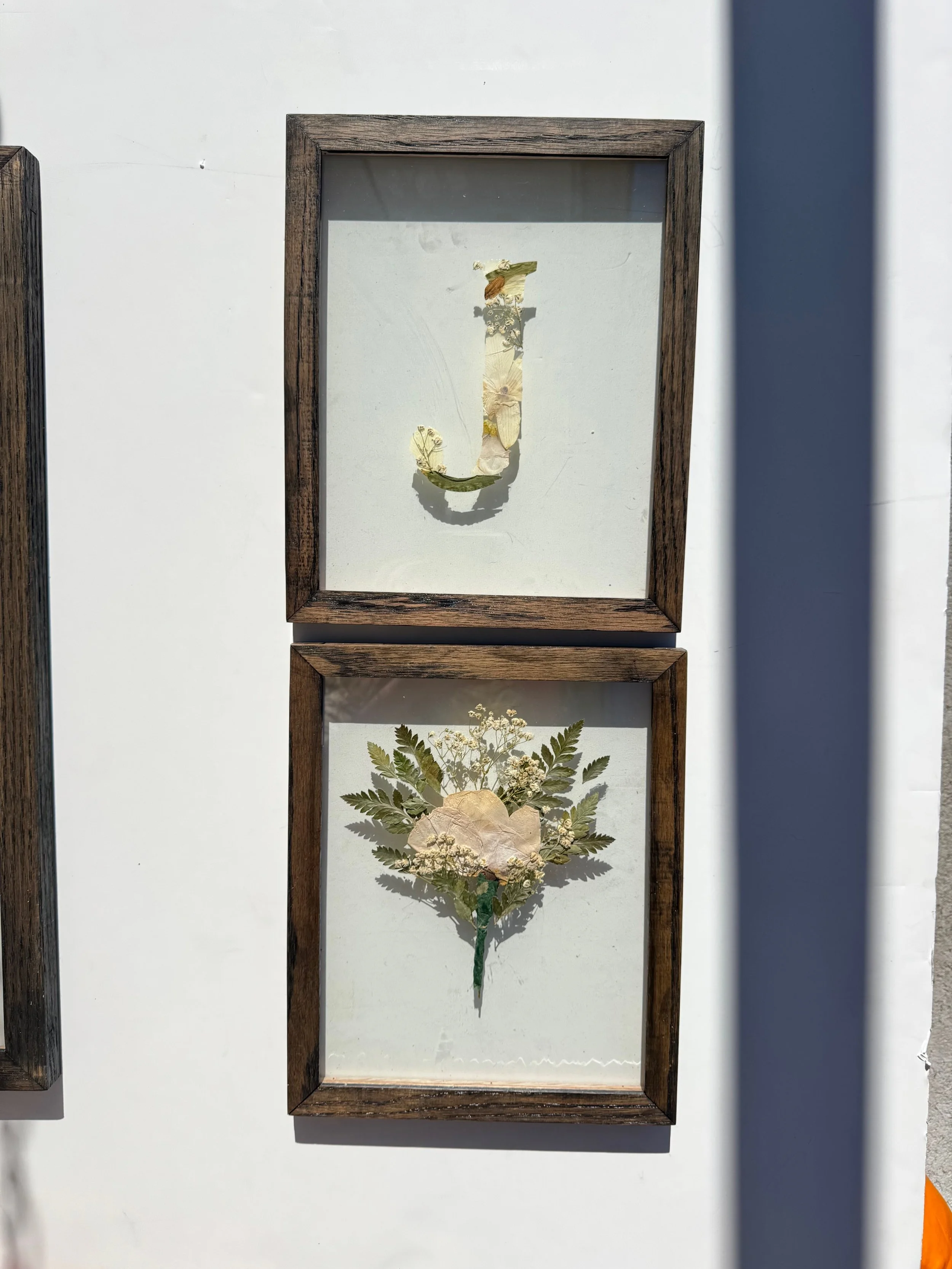One letter monogram in ebony stain paired with a boutonnière preservation both are 8x10.