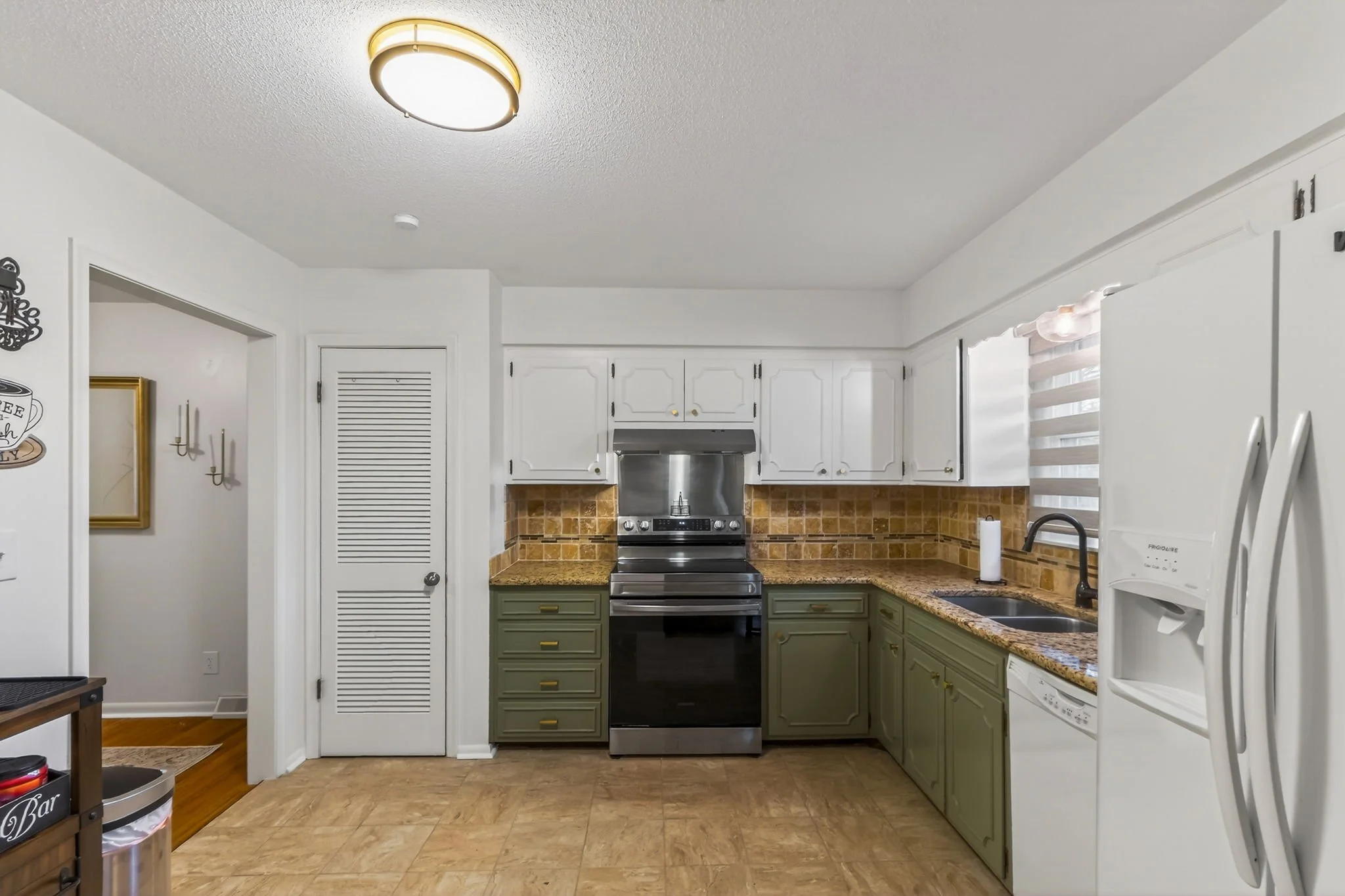 Kitchen with white upper cabinets, green lower cabinets, a black stove, a dishwasher, a refrigerator, and a window with a zebra blind.