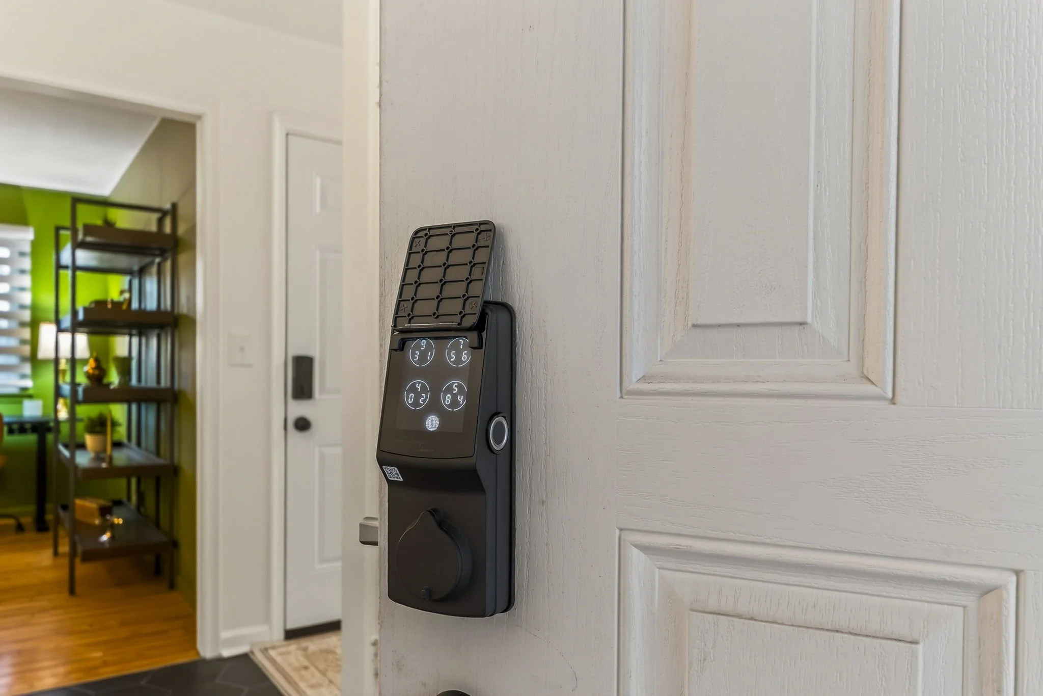 Digital lock keypad on a wall in a home interior.