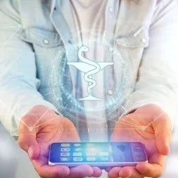 Person hält ein Smartphone mit einem medizinischen Symbol schwebend darüber